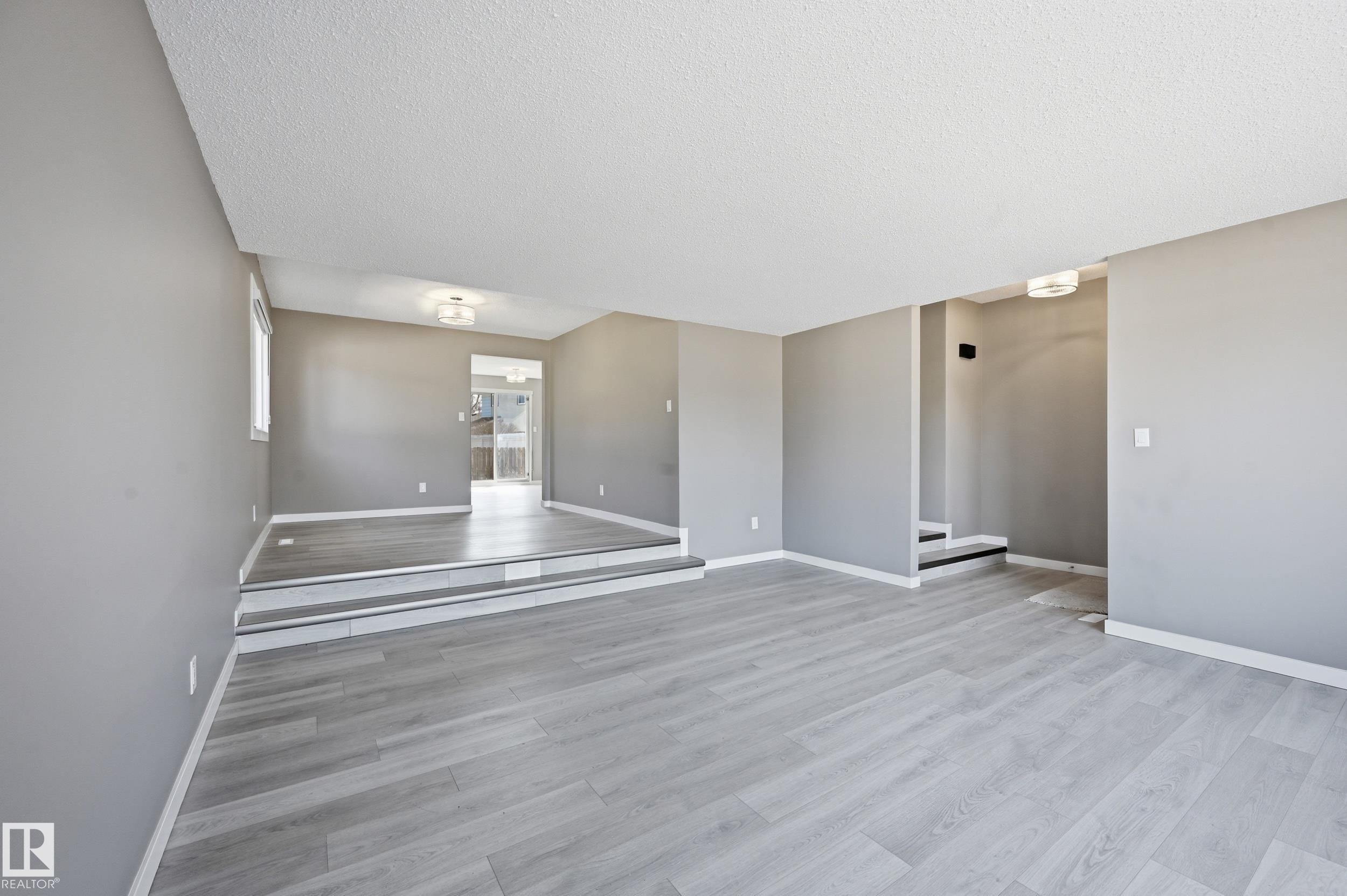 The interior features light gray walls and light-colored flooring, creating a bright and airy atmosphere - 6907 19 Avenue, Edmonton, AB - Indoor Photo Showing Other Room