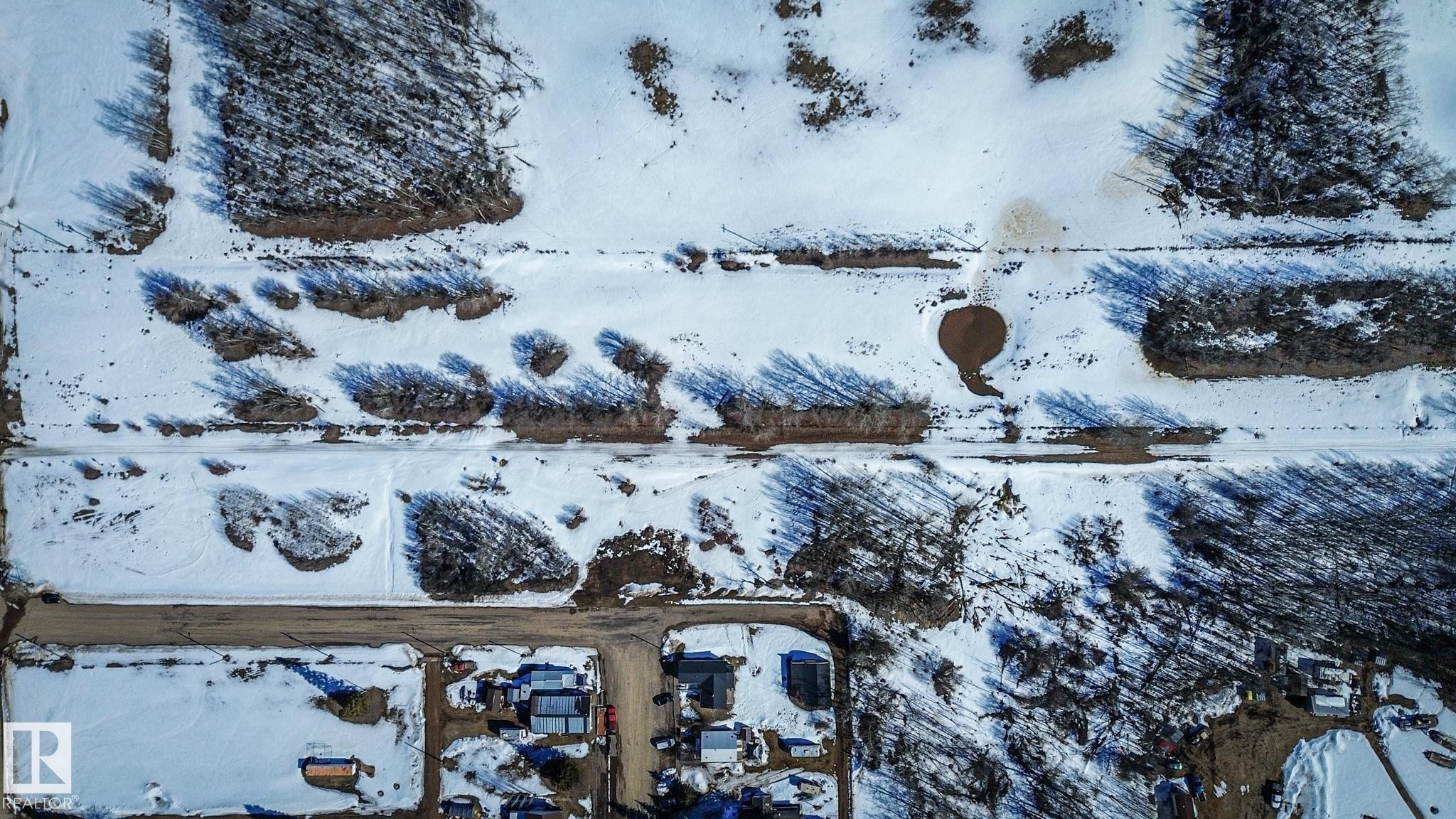 Aerial perspective showcasing snow-covered ground with visible dirt pathways - Sw-34-59-12-4, Spedden, AB