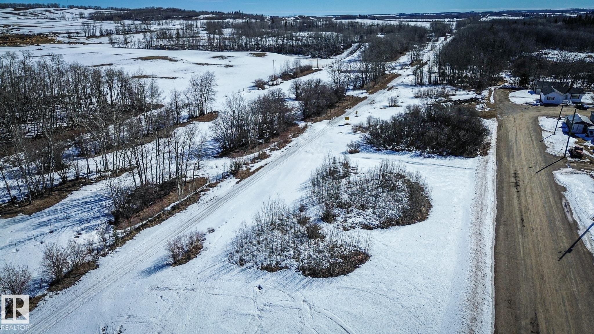 Expansive land parcel featuring a visible road, scattered trees, and snow-covered terrain - Sw-34-59-12-4, Spedden, AB