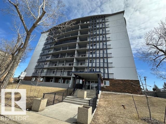 Multi-story residential building featuring a light-colored facade, private balconies with black railings, and a brick base - 86 13435 97 Street, Edmonton, AB - Outdoor