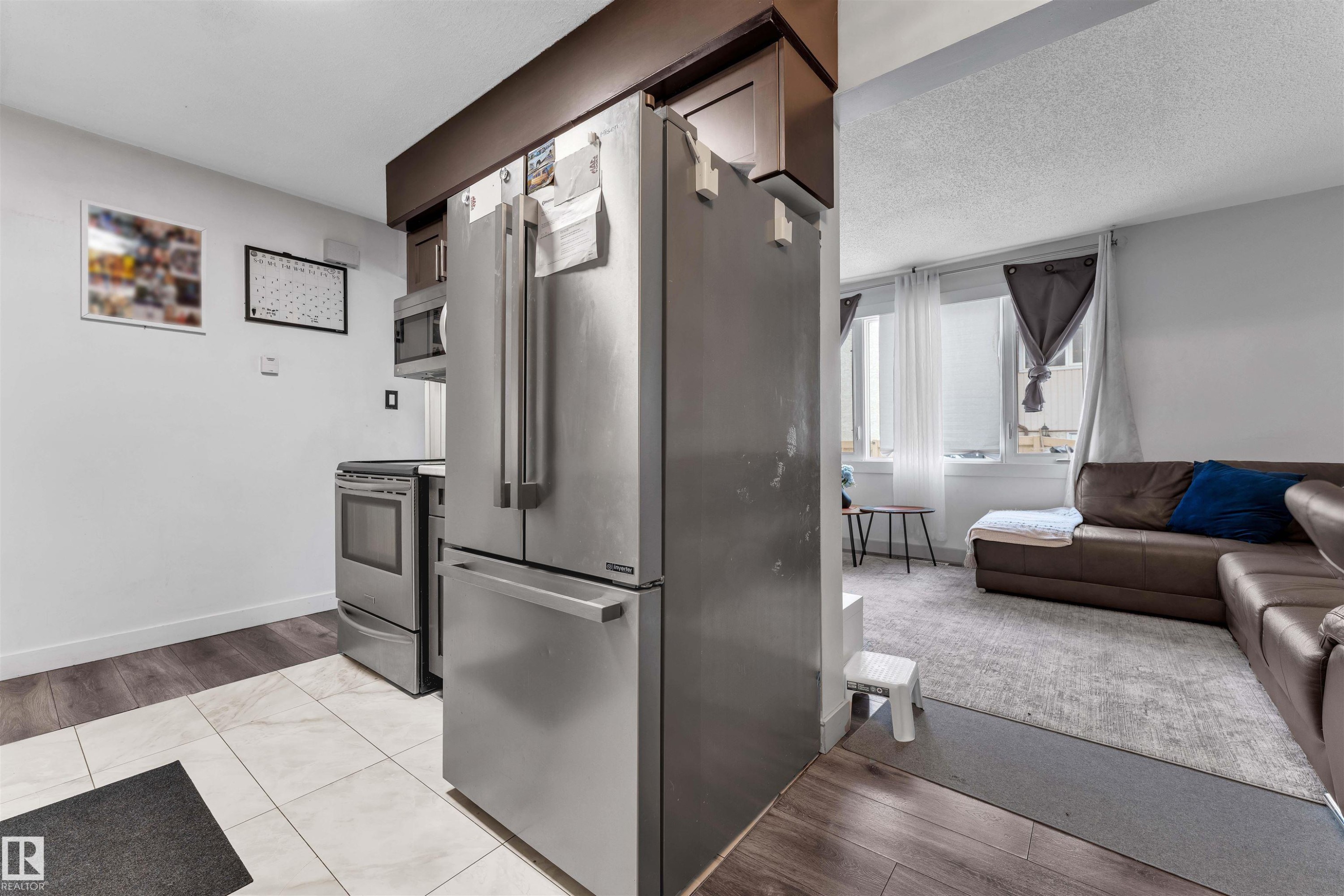 Kitchen area featuring stainless steel appliances including a French door refrigerator, electric range, and built-in microwave - 7 14115 82 Street, Edmonton, AB - Indoor