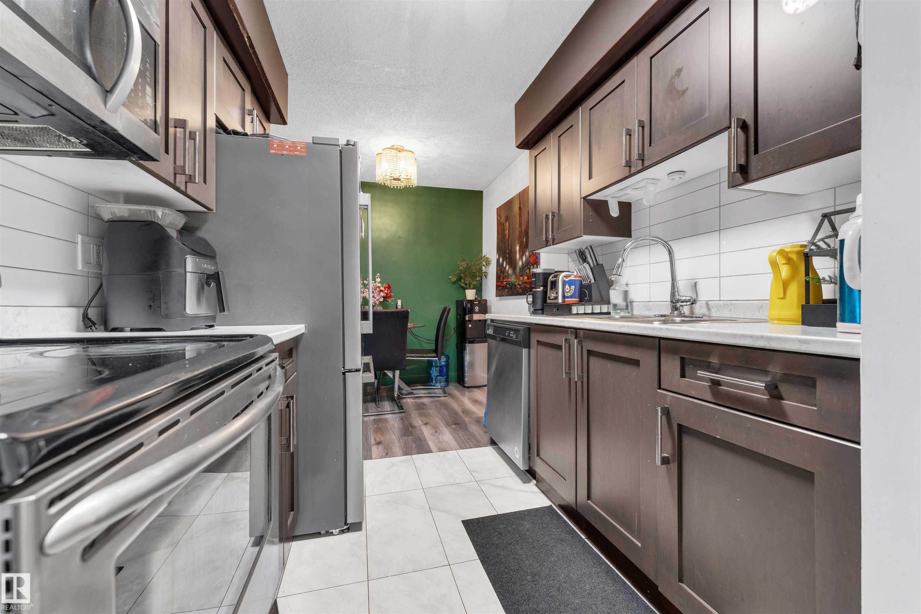 Contemporary kitchen featuring dark wood-finish cabinetry and stainless steel appliances - 7 14115 82 Street, Edmonton, AB - Indoor Photo Showing Kitchen