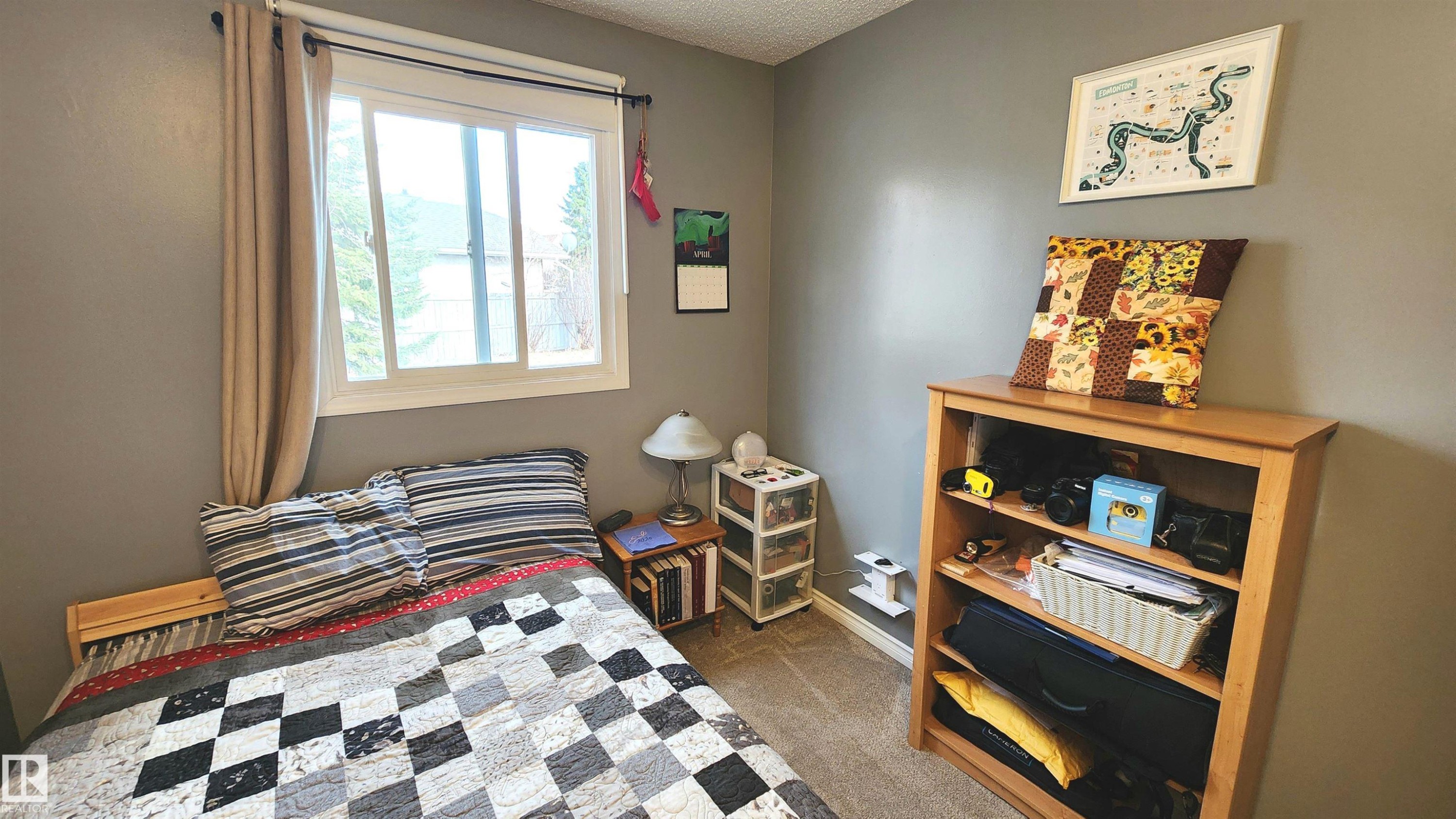 Interior room with neutral gray walls, a white framed window, and light-colored carpeting - 3531 46 Street, Edmonton, AB - Indoor Photo Showing Bedroom