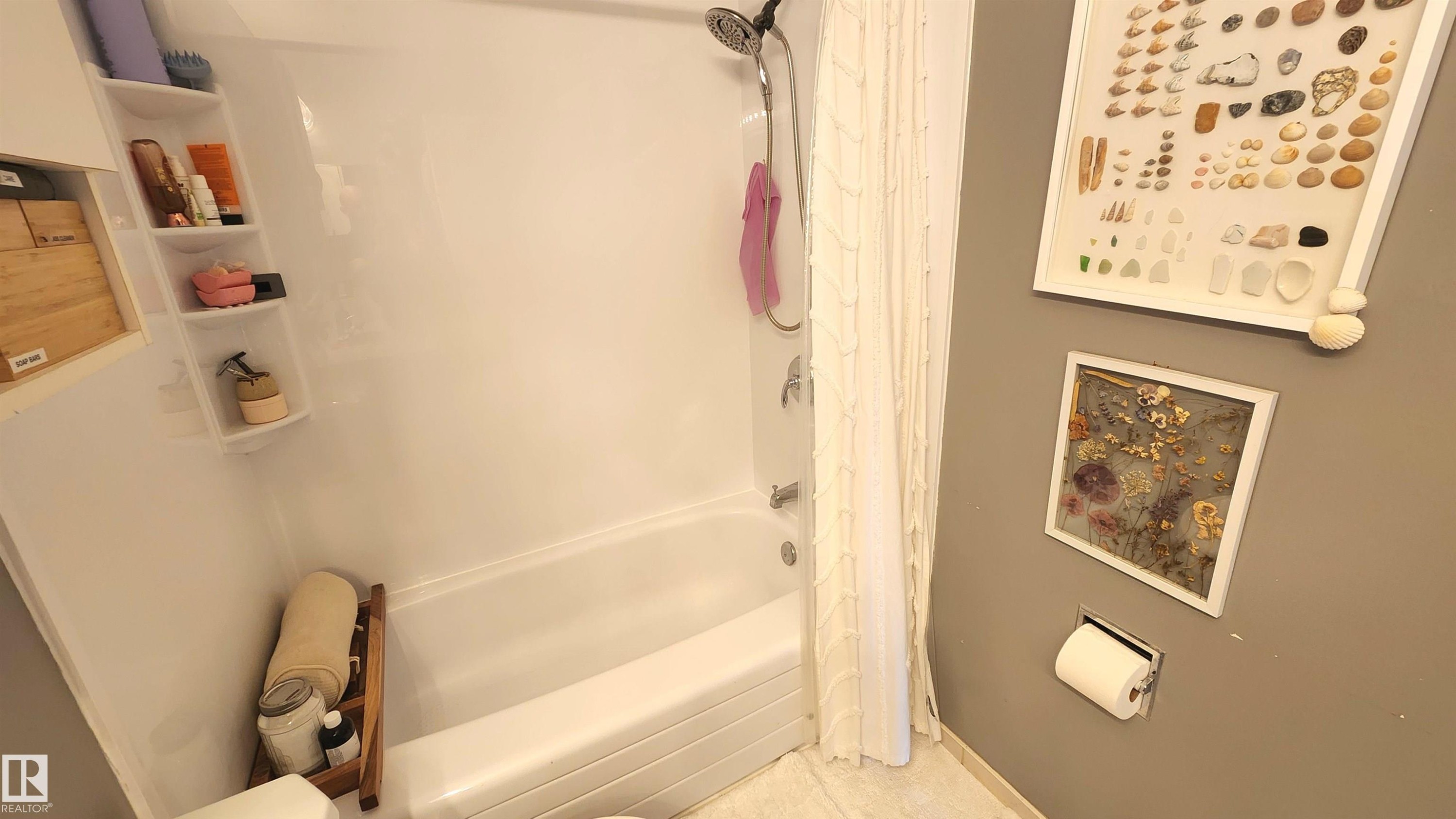 White bathtub and shower combination featuring a curved shower rod and ceiling-mounted showerhead - 3531 46 Street, Edmonton, AB - Indoor Photo Showing Bathroom