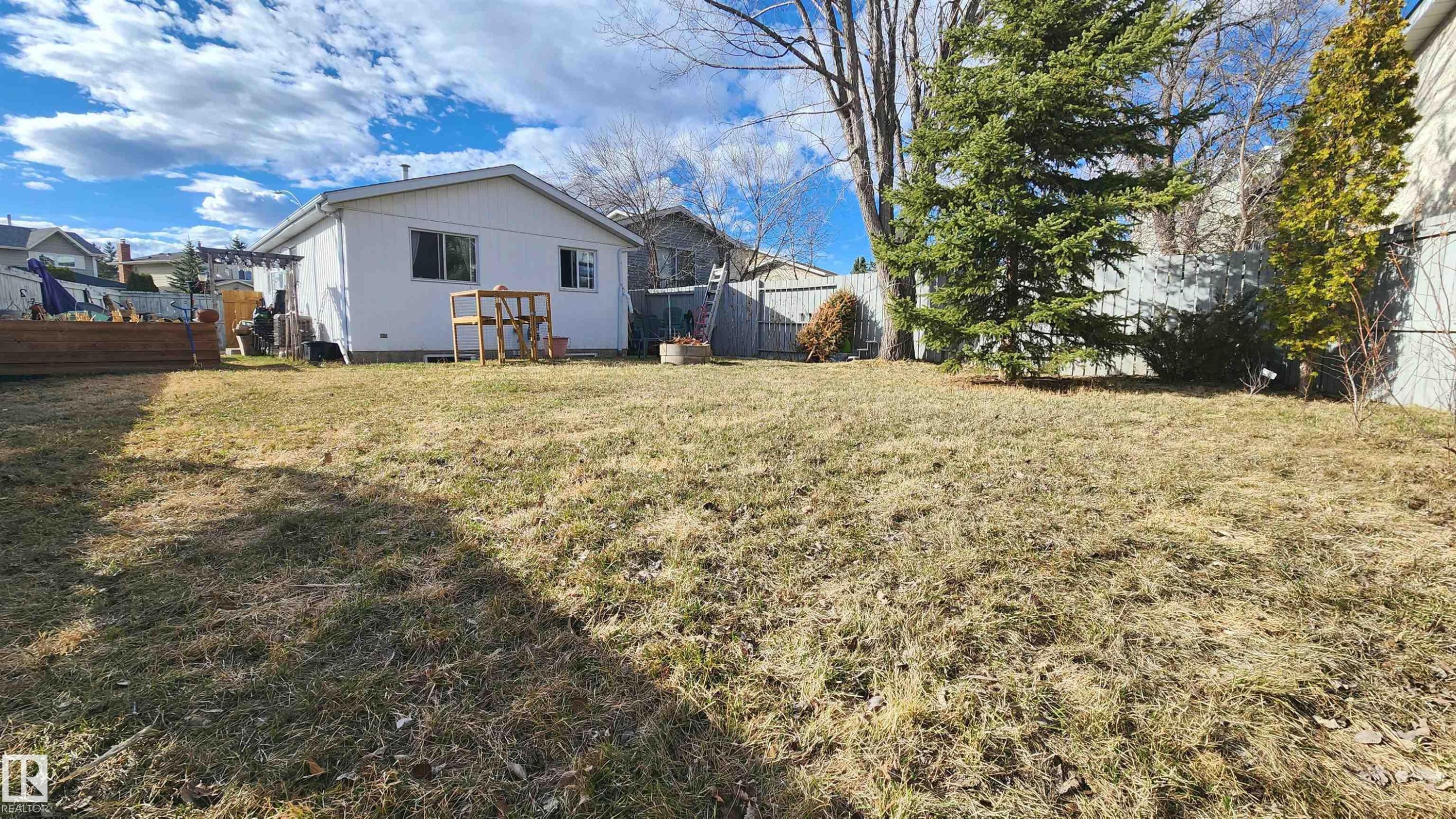 Expansive backyard featuring a broad lawn area, mature trees, and fencing - 3531 46 Street, Edmonton, AB - Outdoor