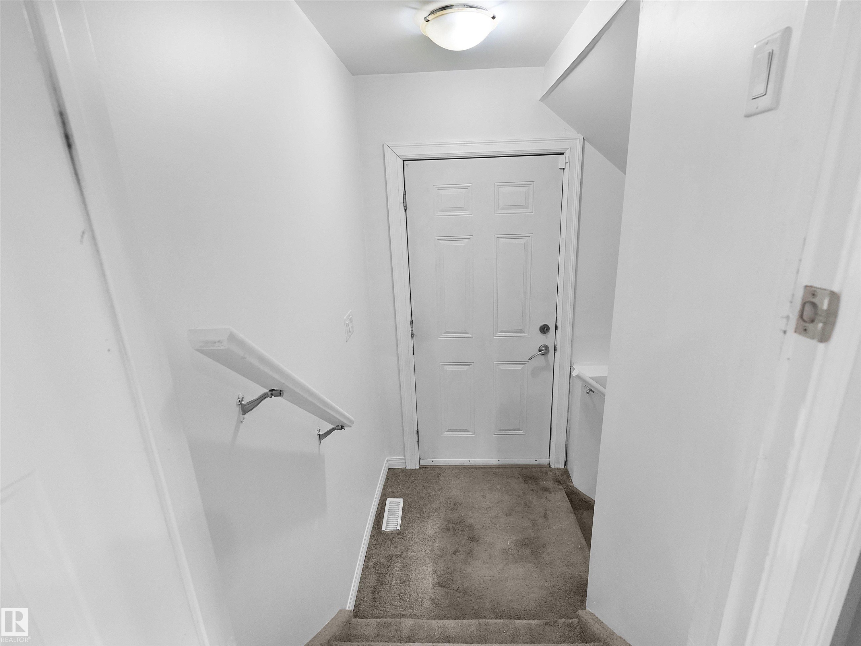 Carpeted staircase with wall-mounted handrail - 5192 1B Avenue Sw, Edmonton, AB - Indoor Photo Showing Other Room