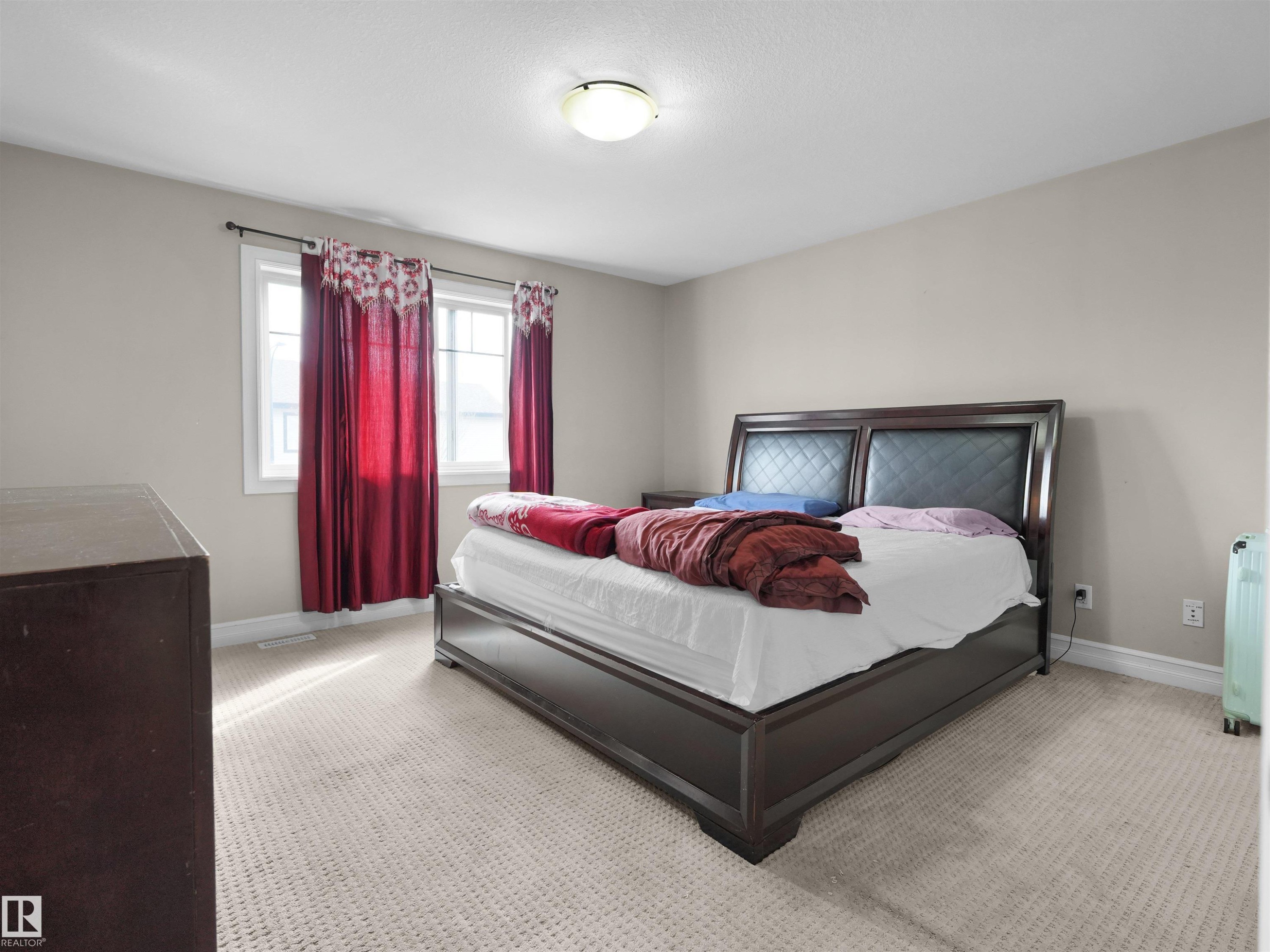 Carpeted room with a double-pane window, neutral-toned walls, and a ceiling-mounted light fixture - 5192 1B Avenue Sw, Edmonton, AB - Indoor Photo Showing Bedroom