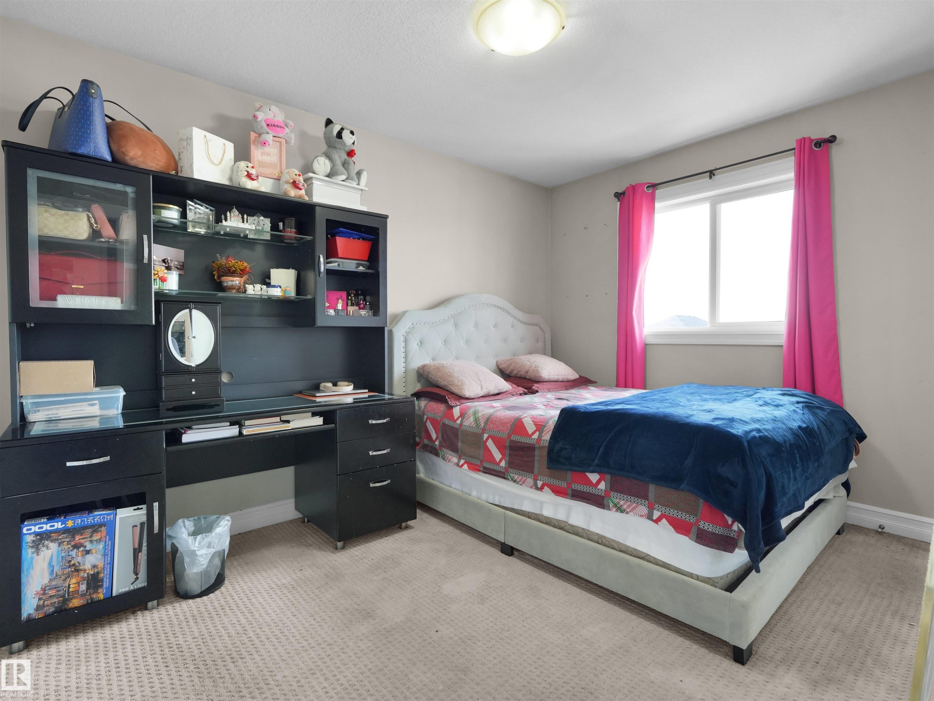 Carpeted bedroom featuring a light-colored wall finish, a window with a white frame, and a flush-mount ceiling light fixture - 5192 1B Avenue Sw, Edmonton, AB - Indoor Photo Showing Bedroom