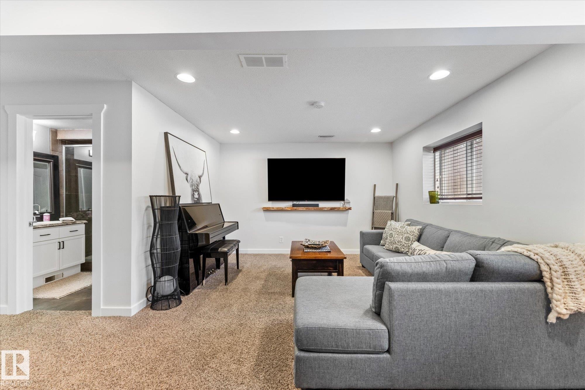 This spacious living area features recessed lighting, carpeted flooring, and a window with blinds - 3908 44 Avenue, Stony Plain, AB - Indoor Photo Showing Living Room
