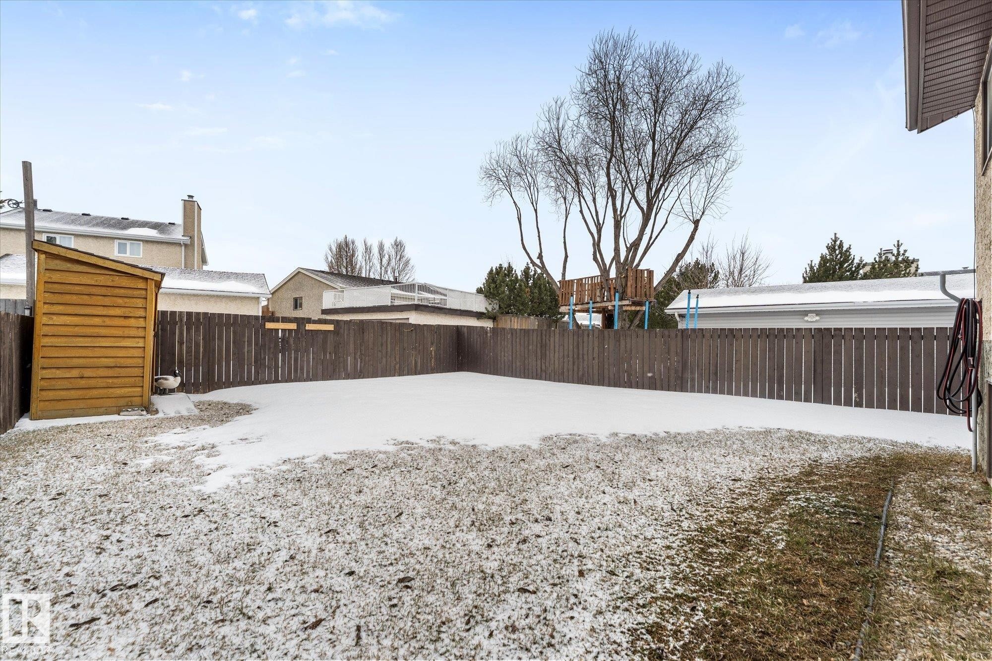 The property features a fenced backyard with a wooden storage shed - 3908 44 Avenue, Stony Plain, AB - Outdoor
