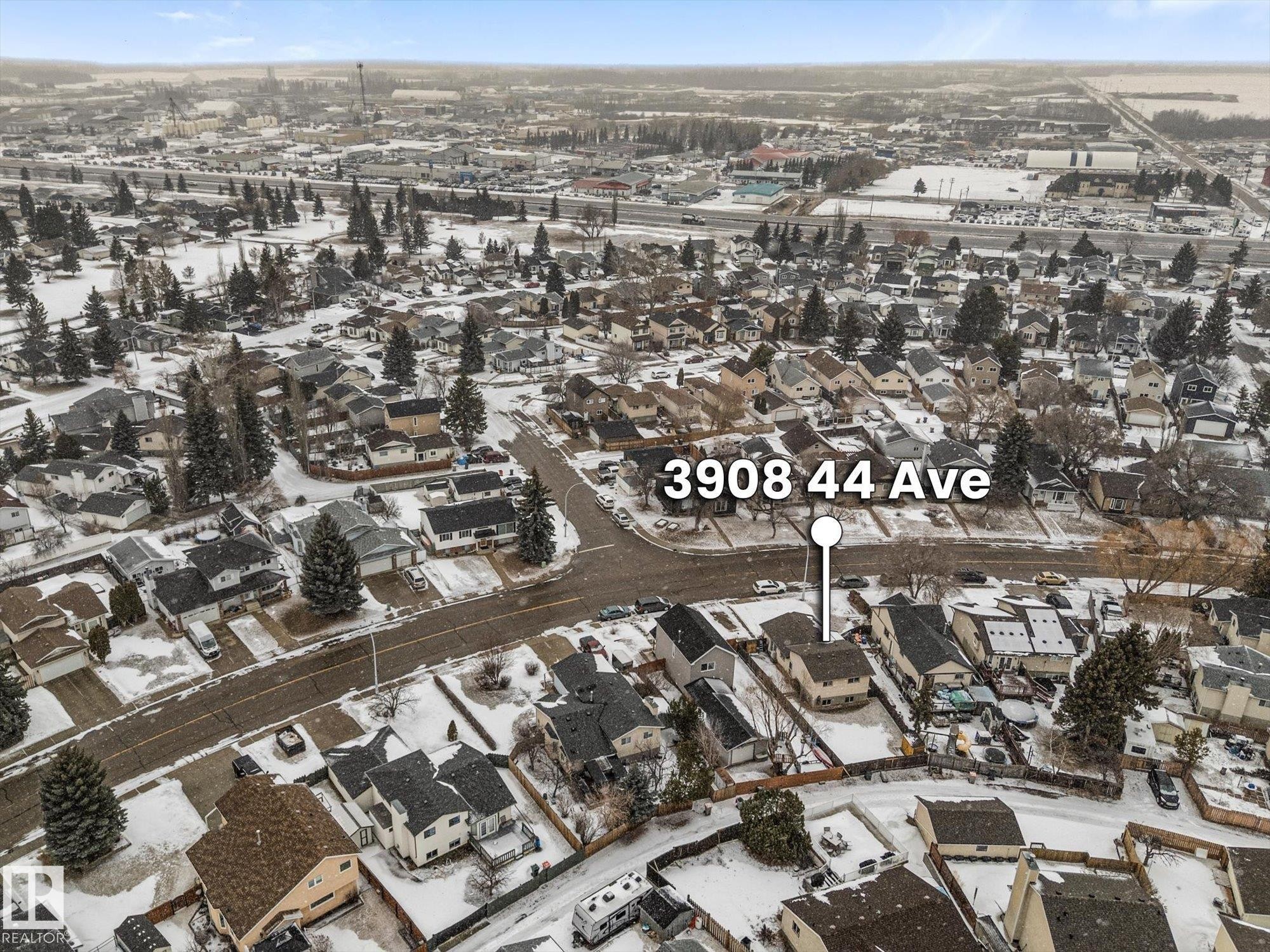 Aerial view of a residential neighborhood with houses featuring various roof styles and a street grid layout - 3908 44 Avenue, Stony Plain, AB - With View
