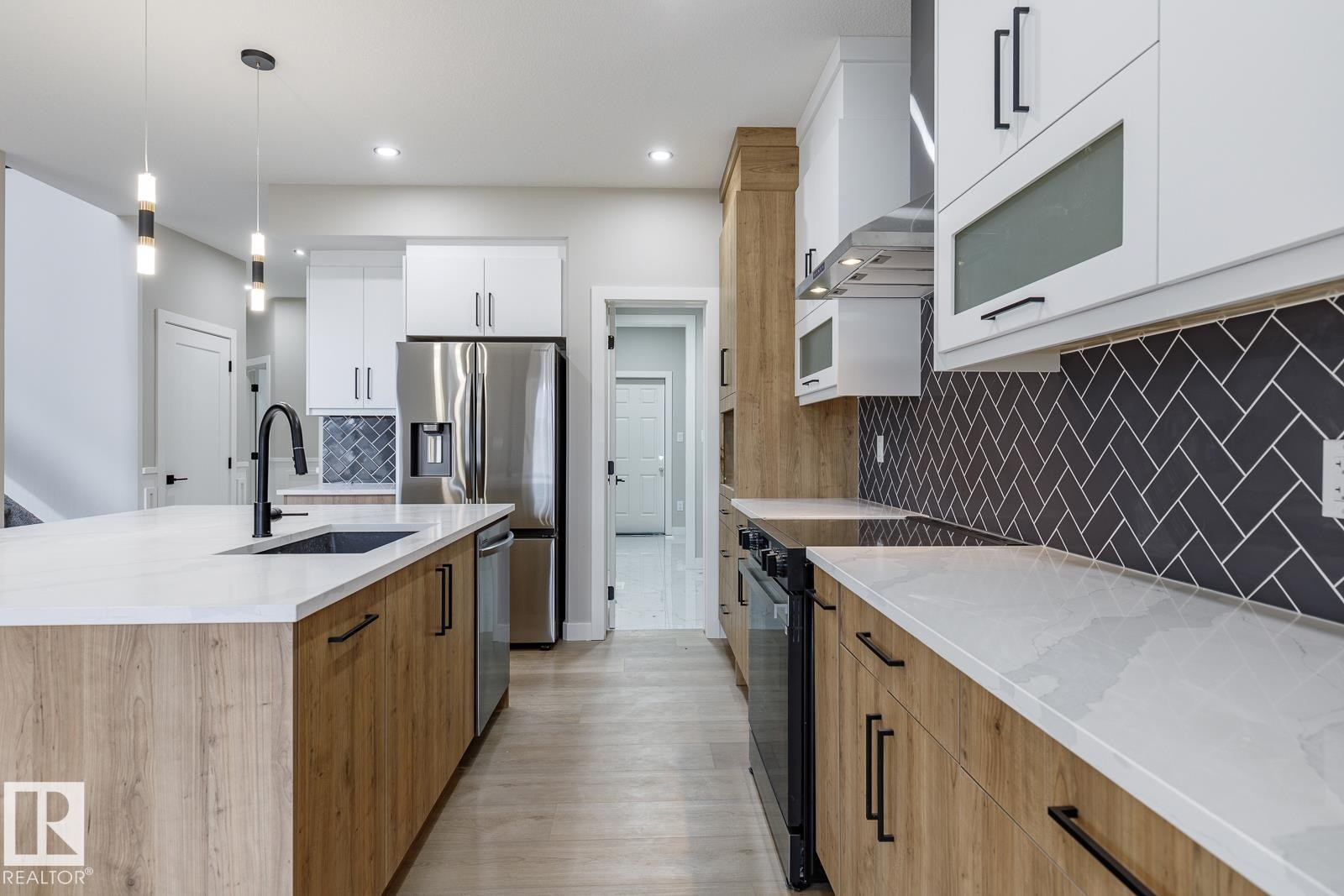 Modern kitchen featuring a large island with an undermount sink and black faucet - 917 Elderberry Landing, Edmonton, AB - Indoor Photo Showing Kitchen With Upgraded Kitchen