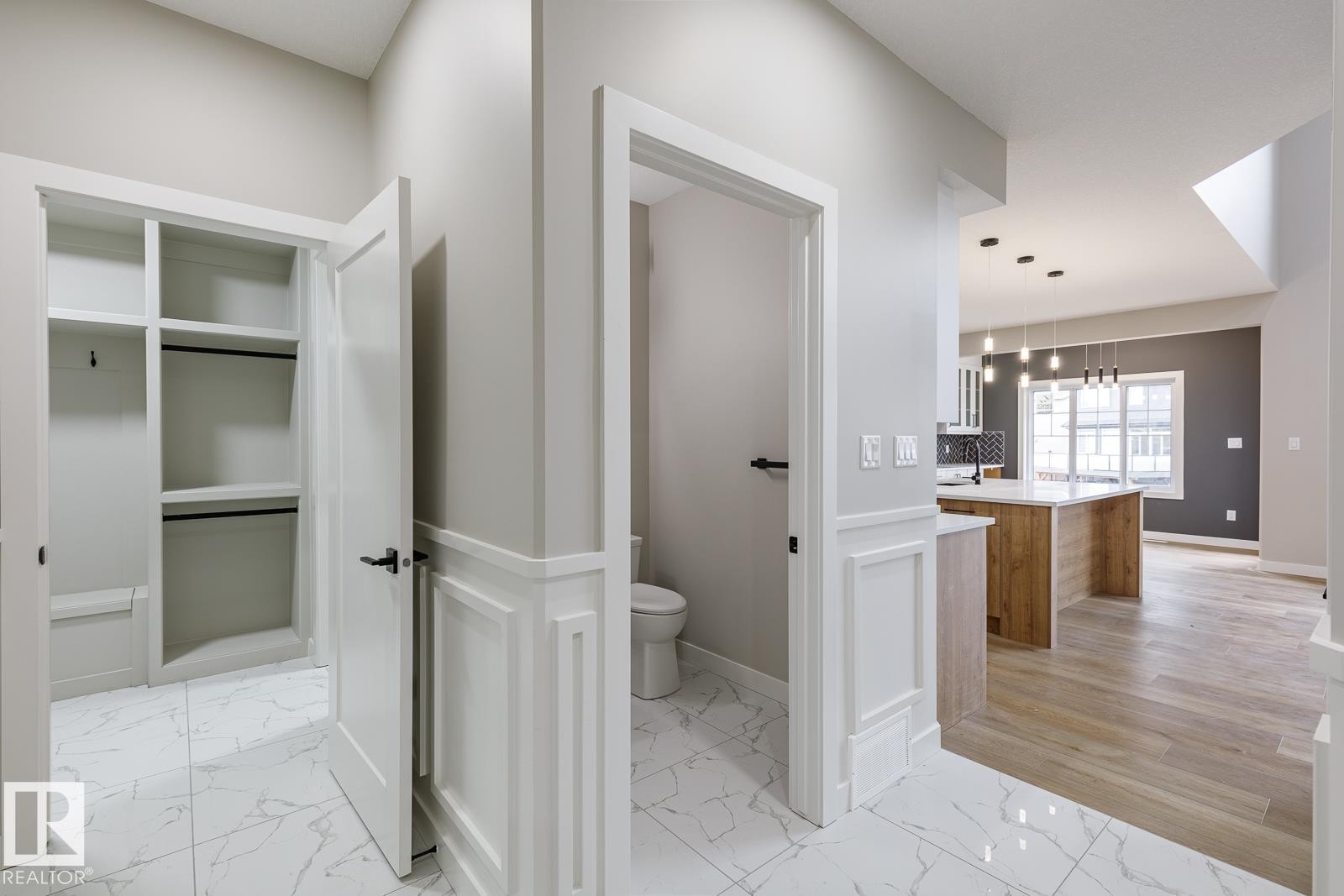 Entryway featuring white marble-look tile flooring and wainscoting, with a built-in closet system - 917 Elderberry Landing, Edmonton, AB - Indoor Photo Showing Other Room