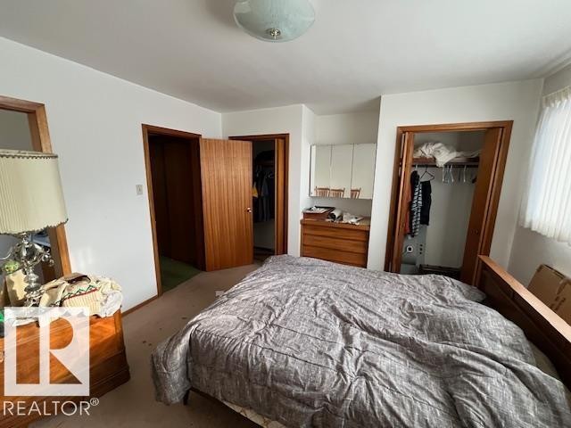 The property features a bedroom with a bed frame, wood doors, and a ceiling light fixture - 11003 144 Street, Edmonton, AB - Indoor Photo Showing Bedroom
