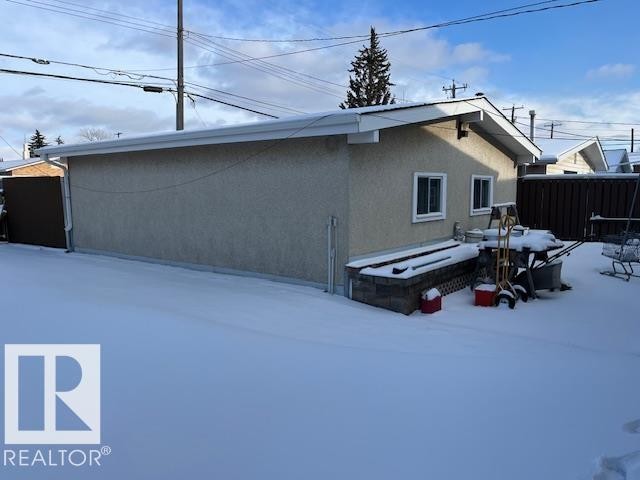 Detached garage with a pitched roof and two windows, set within a snow-covered yard - 11003 144 Street, Edmonton, AB - Outdoor