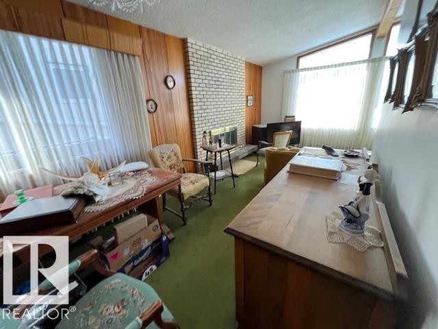 Living area featuring wood paneling, a brick fireplace, and large windows with privacy blinds - 11003 144 Street, Edmonton, AB - Indoor