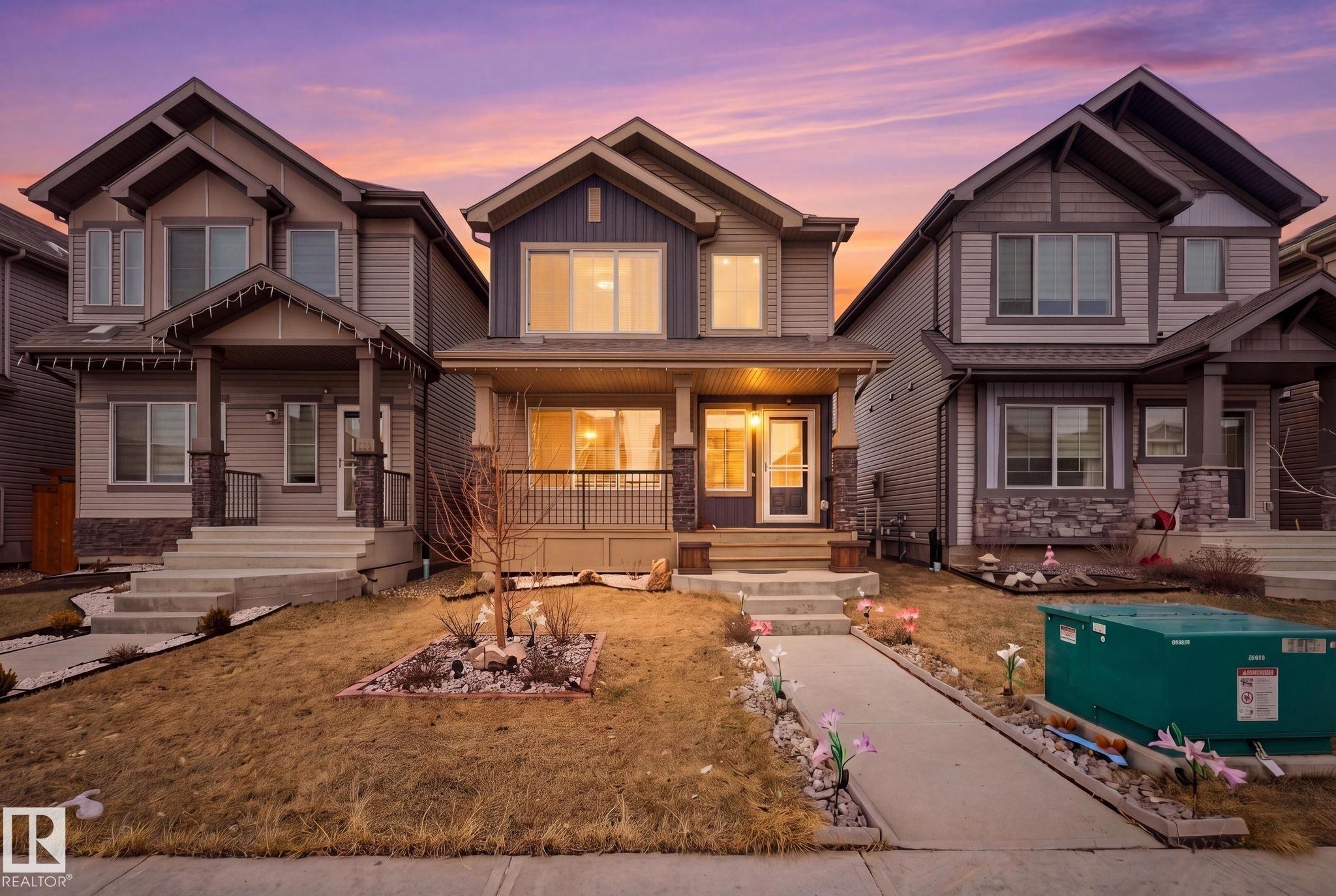 This property features a welcoming front porch with decorative railings, complemented by exterior siding and stone accents - 4636 175 Ave, Edmonton, AB - Outdoor With Facade