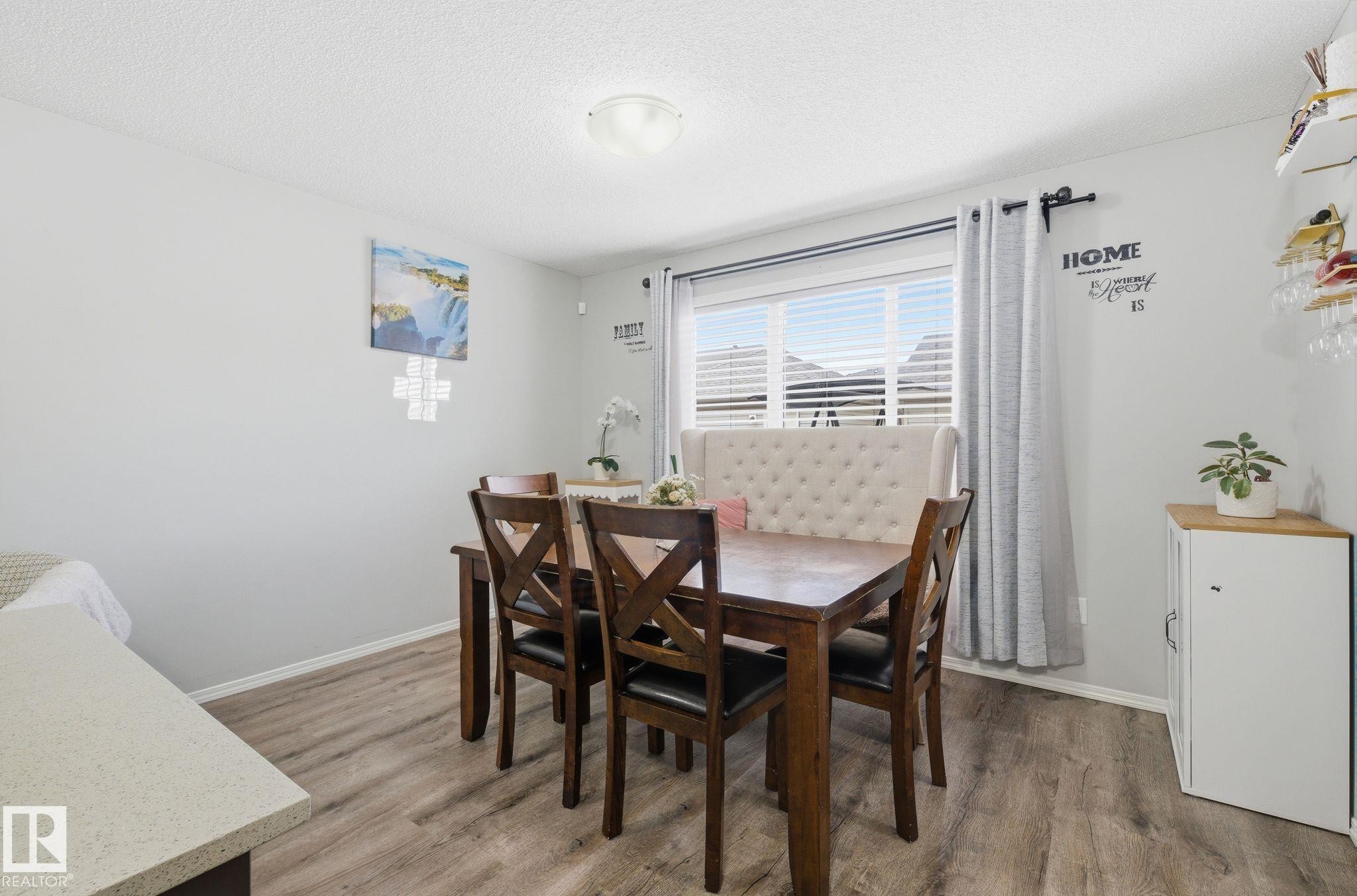 Dining area featuring light wood tone flooring, a window with horizontal blinds, and a ceiling light fixture - 4636 175 Ave, Edmonton, AB - Indoor Photo Showing Dining Room