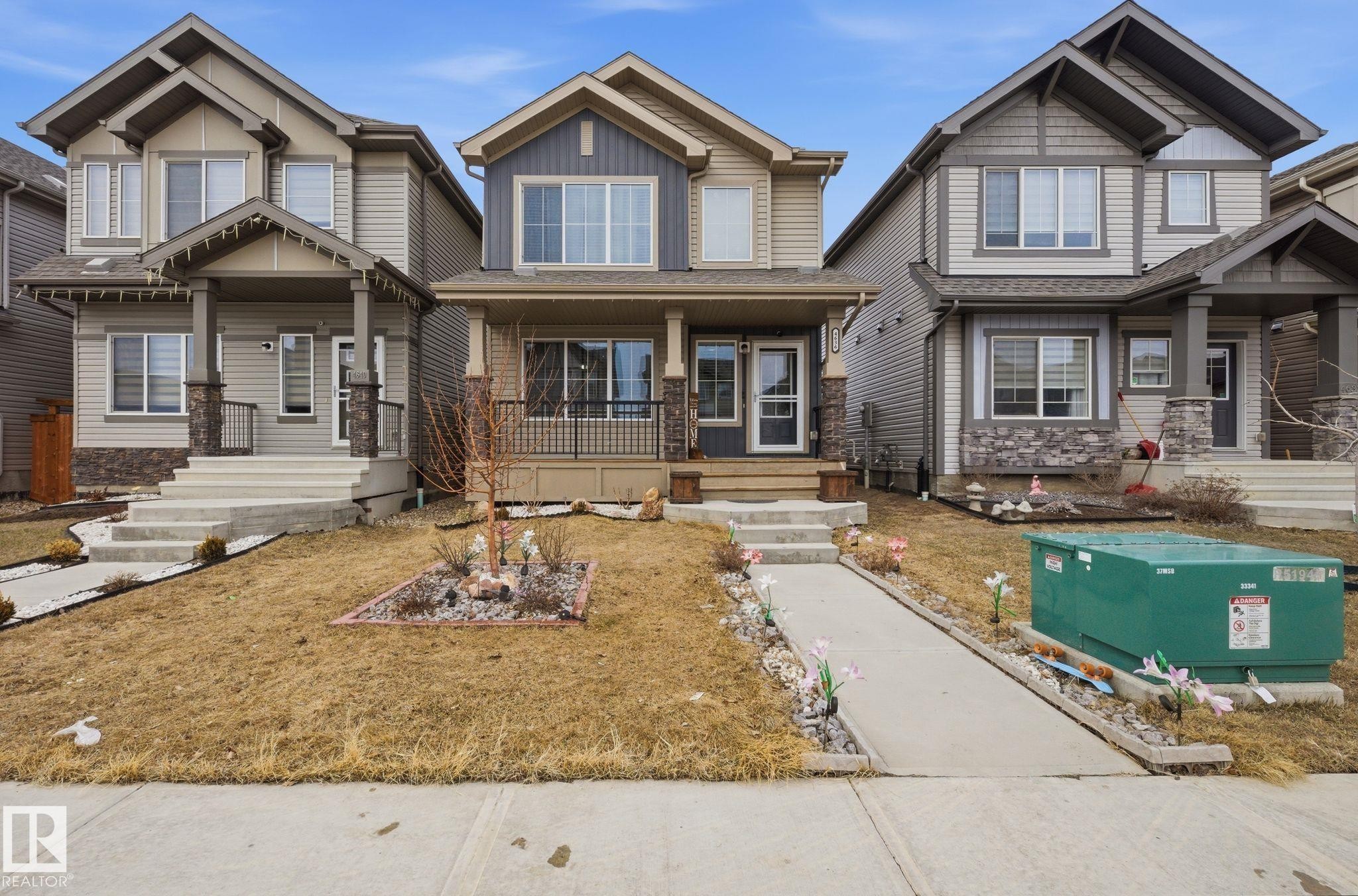 The property features a charming exterior with a covered front porch, stone accents, and a well-maintained front yard - 4636 175 Ave, Edmonton, AB - Outdoor With Facade