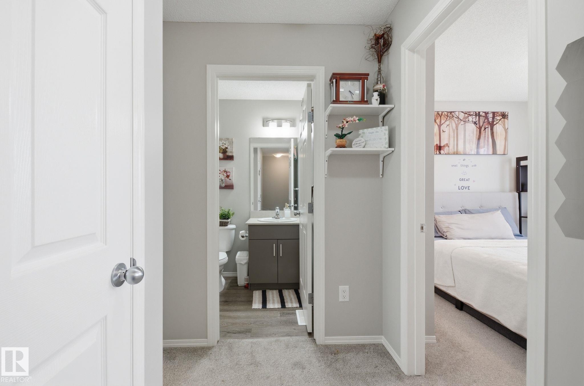 This property features a well-appointed bathroom with a vanity and mirror, and a bedroom with a bed and a headboard - 4636 175 Ave, Edmonton, AB - Indoor