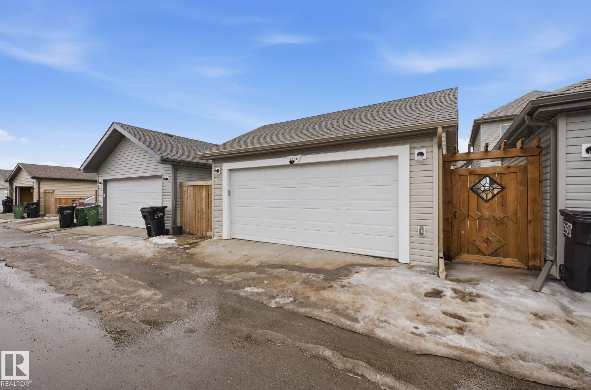 The property includes a detached garage with a white garage door and light-colored siding - 4636 175 Ave, Edmonton, AB - Outdoor With Exterior