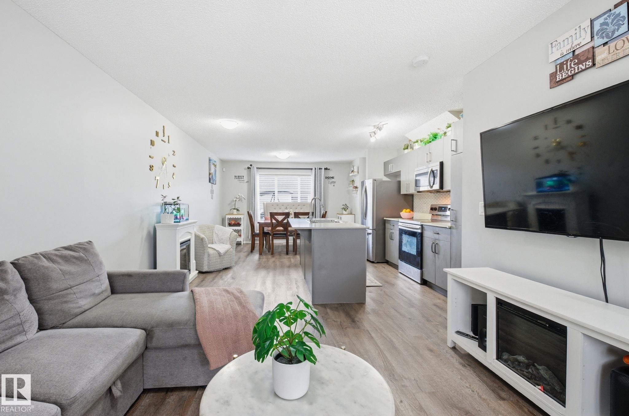 Open concept living space featuring hardwood style flooring, a neutral color palette, and recessed lighting - 4636 175 Ave, Edmonton, AB - Indoor Photo Showing Living Room