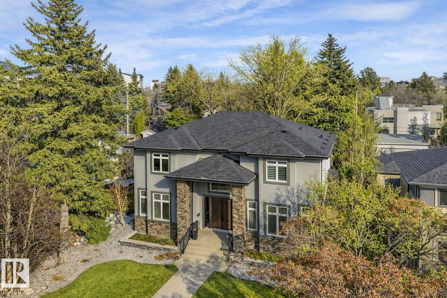 Contemporary exterior with a dark grey stucco finish, stone accents, and a prominent front entry with an overhang - 8927 120 Street Nw, Edmonton, AB - Outdoor