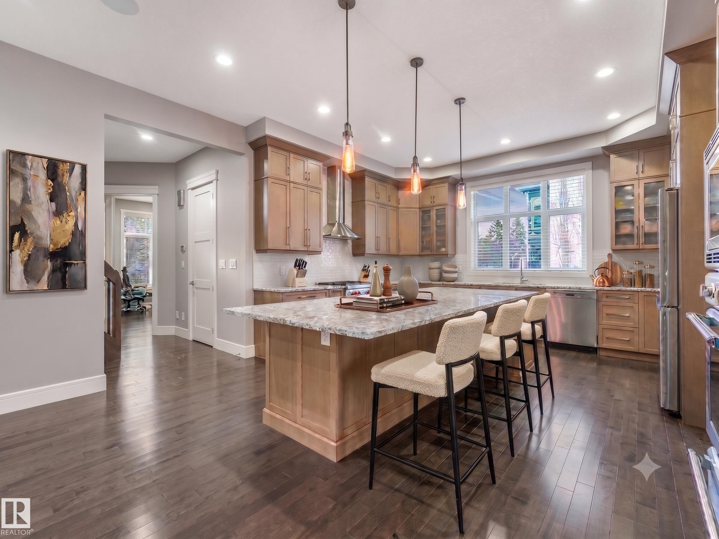 Gourmet kitchen featuring a large island with seating, stainless steel appliances, light wood cabinetry, and recessed lighting - 8927 120 Street Nw, Edmonton, AB - Indoor