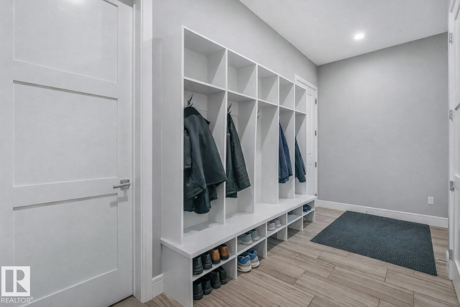 Mudroom featuring extensive built-in white cabinetry with individual storage cubbies and coat hooks - 8927 120 Street Nw, Edmonton, AB - Indoor Photo Showing Other Room