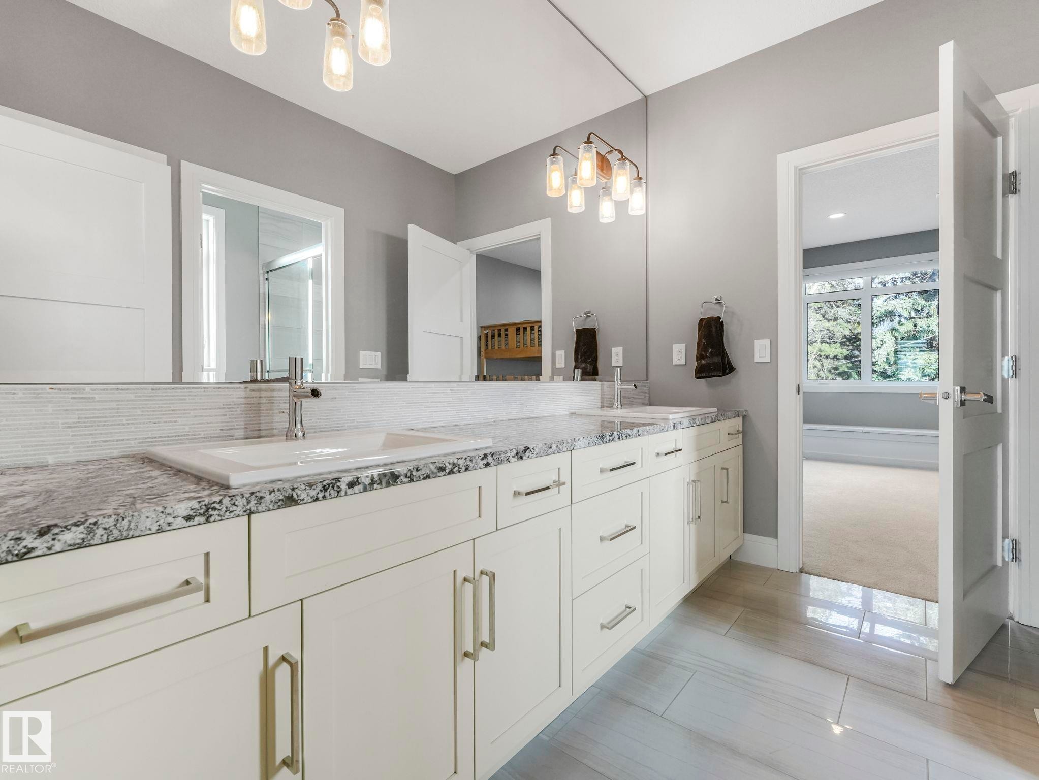 Double vanity featuring granite countertops, undermount sinks, and contemporary fixtures - 8927 120 Street Nw, Edmonton, AB - Indoor Photo Showing Bathroom