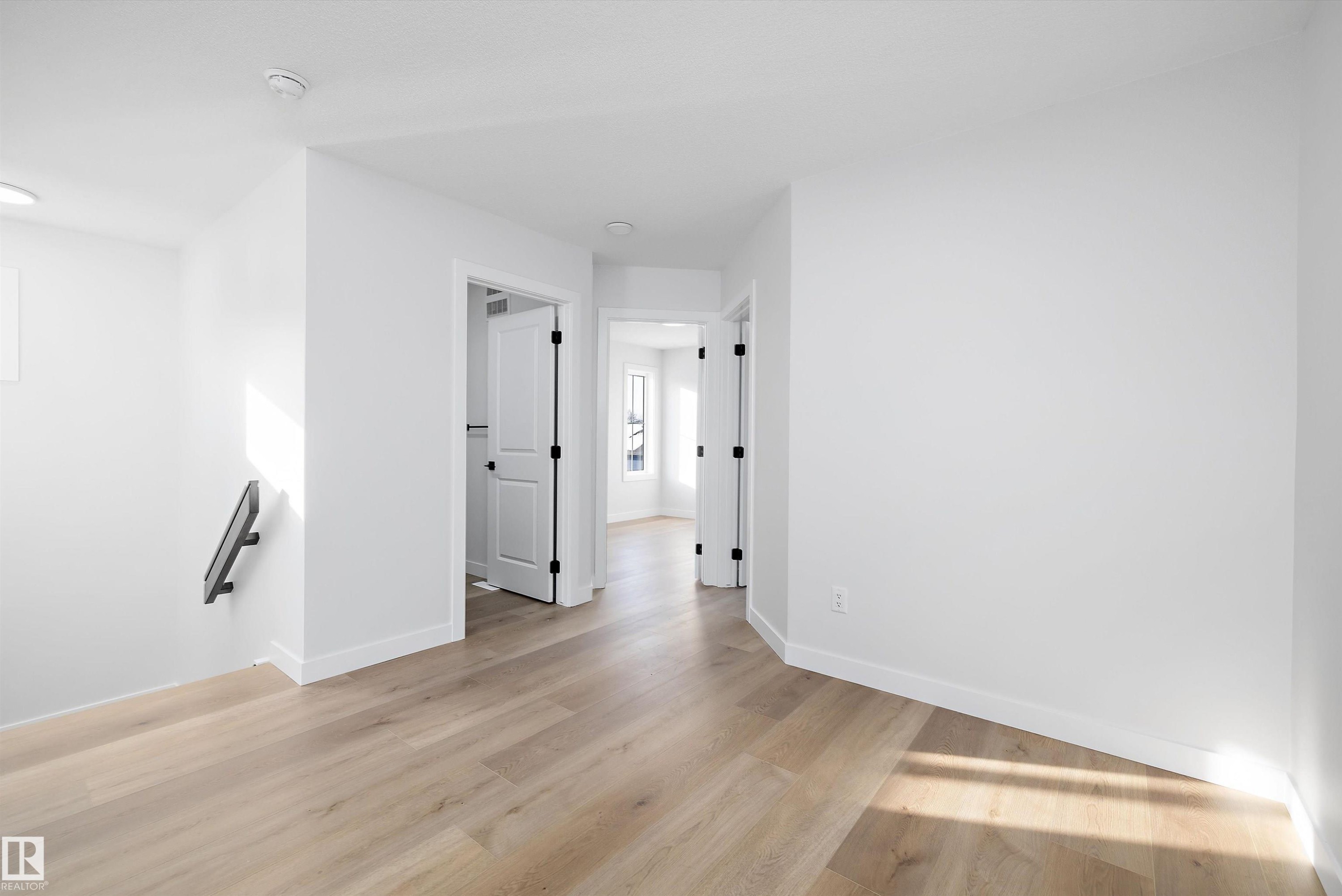 Bright interior space featuring light wood-finish flooring, crisp white walls, and contemporary baseboards - 954 Elderberry Landing, Edmonton, AB - Indoor Photo Showing Other Room