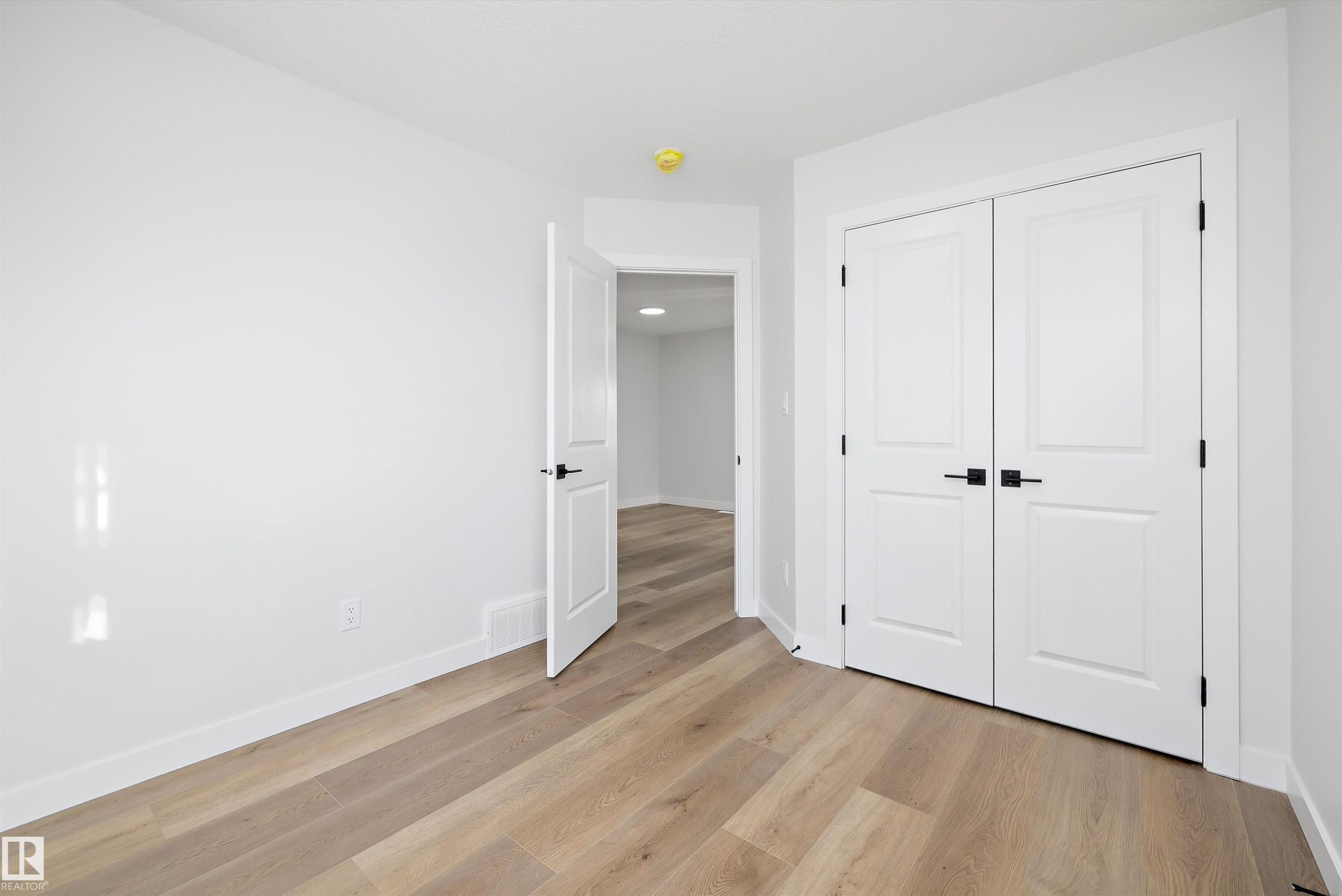 Room featuring light wood-finish flooring, white walls, and white baseboards - 954 Elderberry Landing, Edmonton, AB - Indoor Photo Showing Other Room
