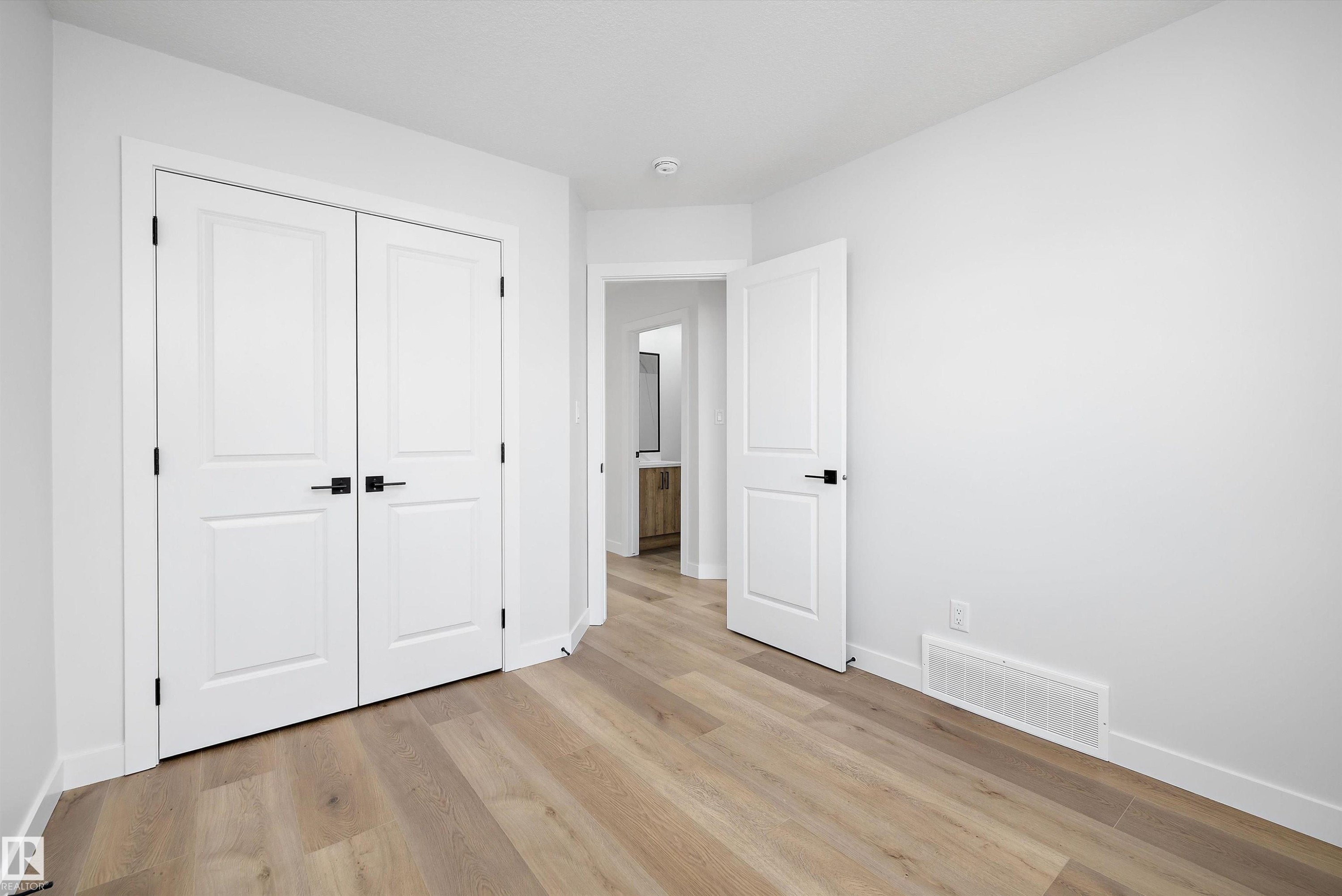Interior room featuring light wood-finish flooring and white baseboards - 954 Elderberry Landing, Edmonton, AB - Indoor Photo Showing Other Room