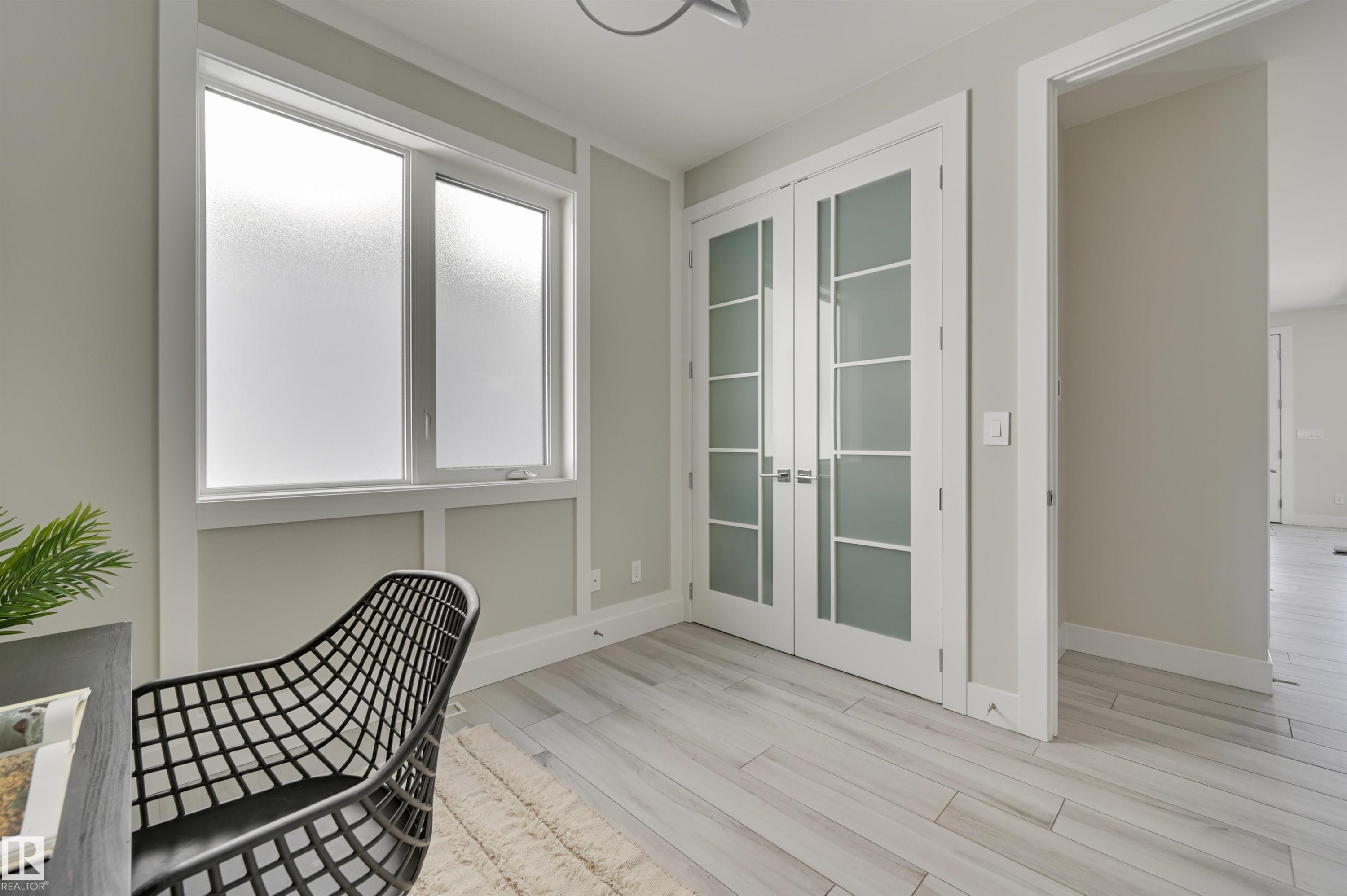 Room featuring frosted window, white trim, and light wood-finish flooring - 9741 90 Avenue, Edmonton, AB - Indoor