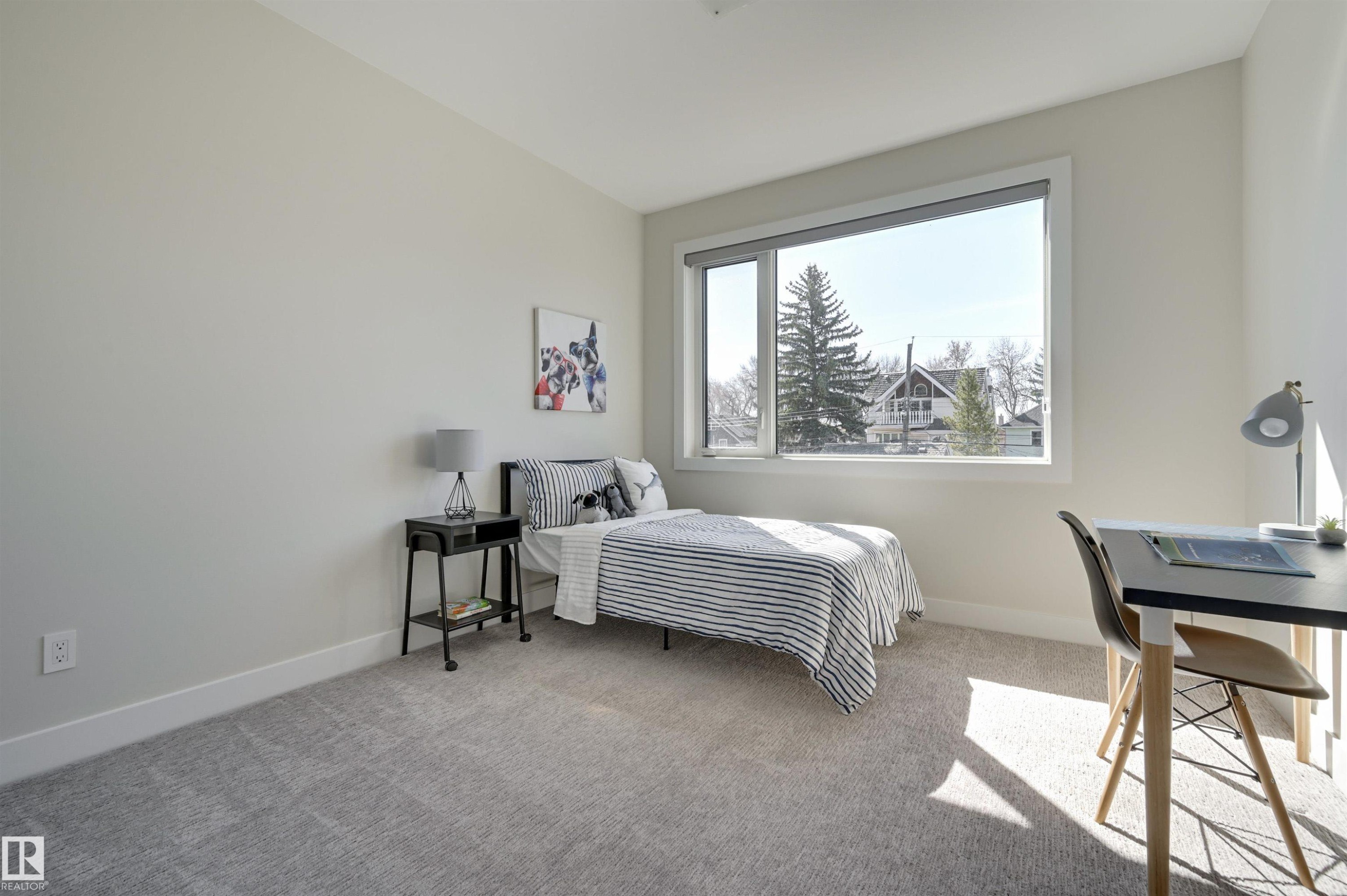 Bedroom featuring light gray wall paint, white trim, gray carpet flooring, and a large window with white framing - 9741 90 Avenue, Edmonton, AB - Indoor Photo Showing Bedroom