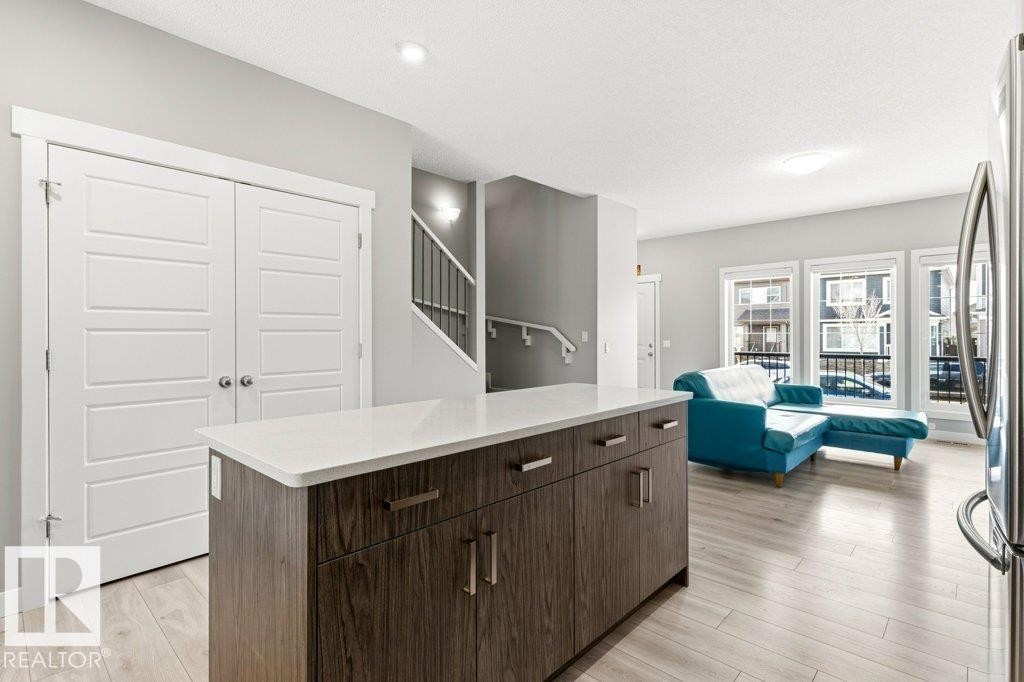 Kitchen island featuring a white countertop and wood-finish cabinetry - 17451 77 Street, Edmonton, AB - Indoor