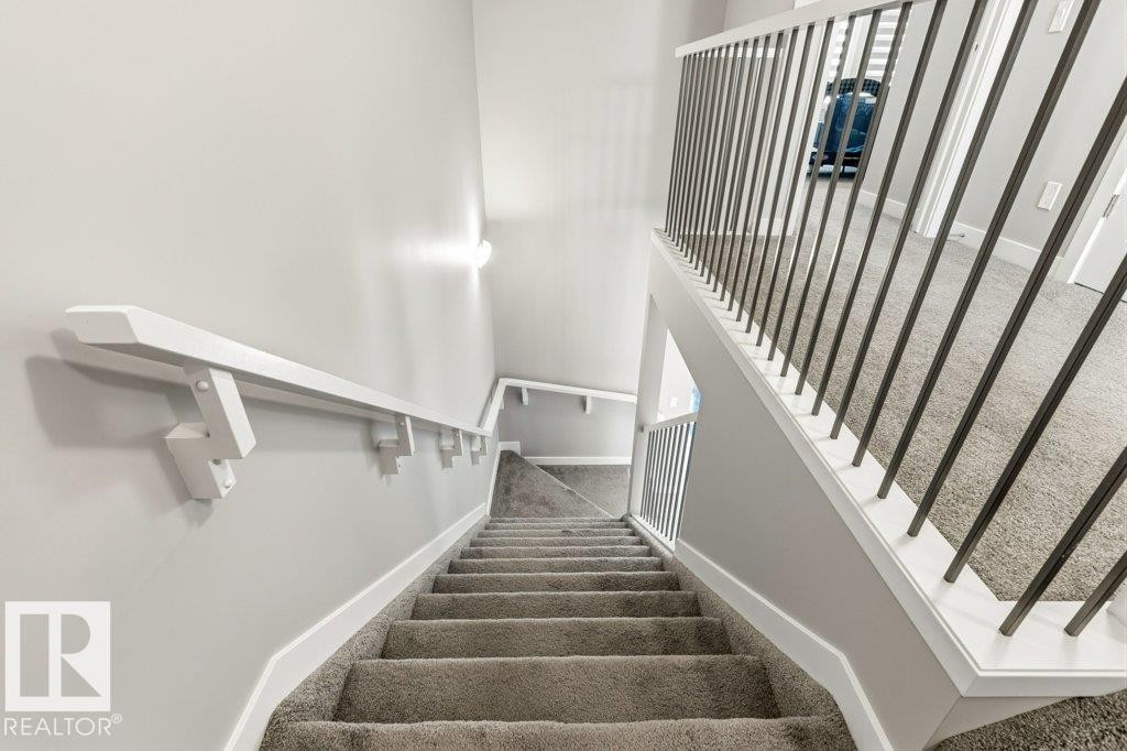 Carpeted staircase with white trim, a white handrail, and a metal spindle railing - 17451 77 Street, Edmonton, AB - Indoor Photo Showing Other Room