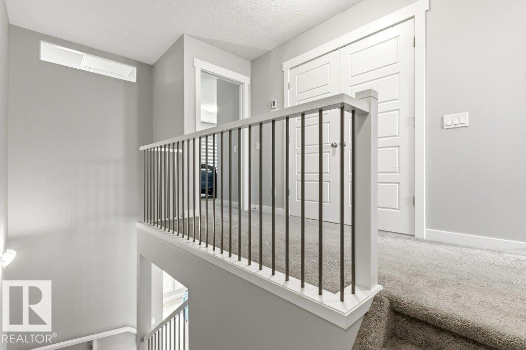 Upper-level landing featuring a contemporary white railing with dark metal spindles - 17451 77 Street, Edmonton, AB - Indoor Photo Showing Other Room