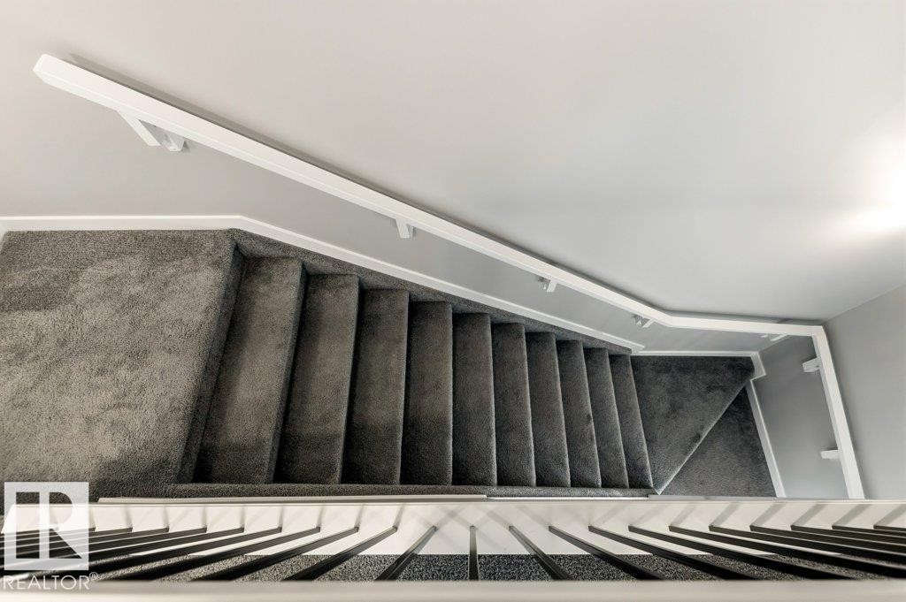 Carpeted staircase featuring a white handrail and white balusters - 17451 77 Street, Edmonton, AB - Indoor