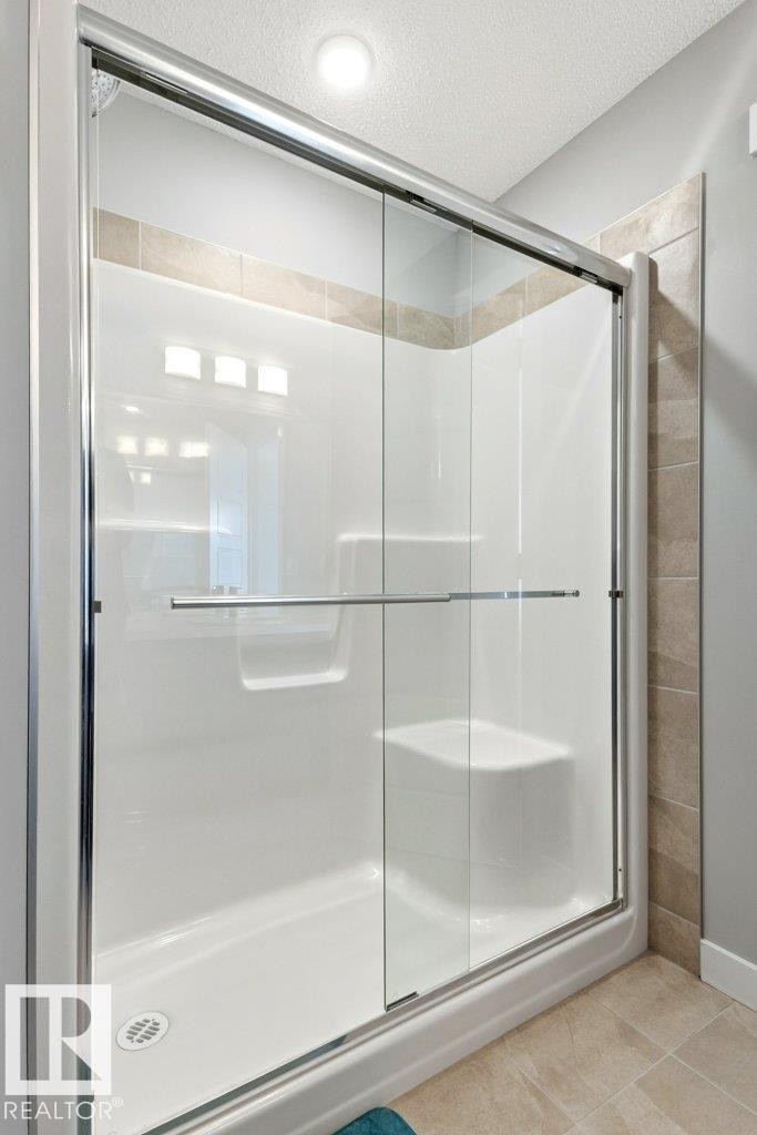 Full shower enclosure with clear glass sliding doors and polished chrome framing - 17451 77 Street, Edmonton, AB - Indoor Photo Showing Bathroom
