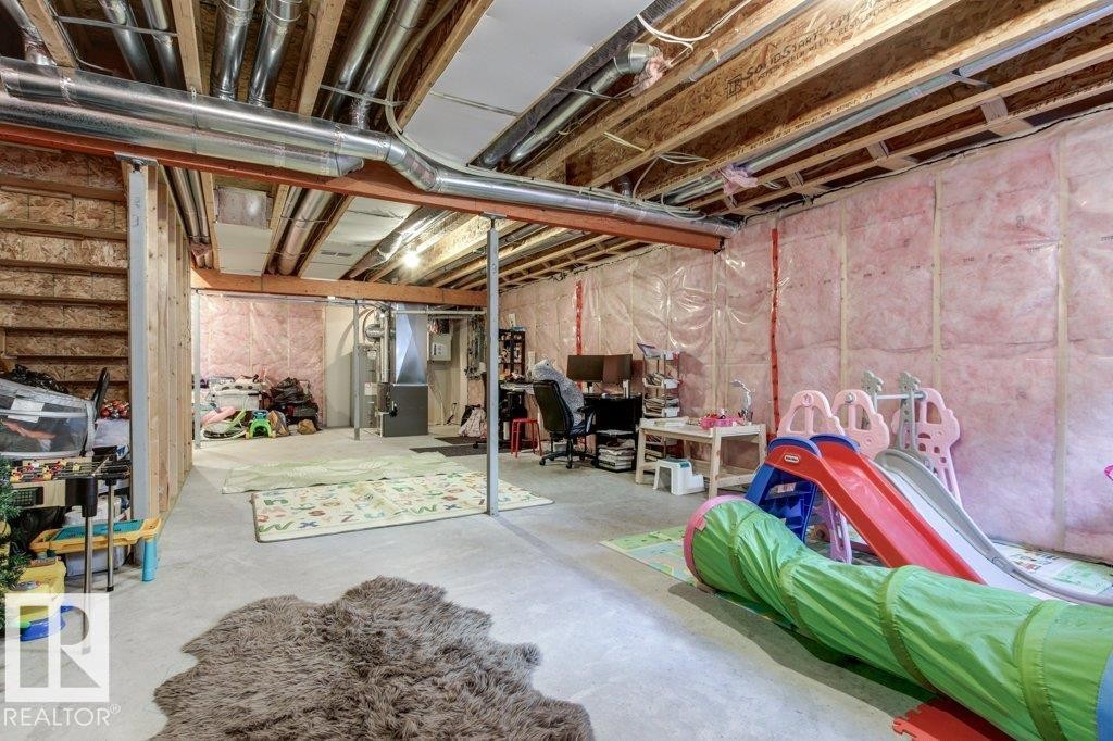 Unfinished basement featuring exposed wood joists, ductwork, and insulated walls - 17451 77 Street, Edmonton, AB - Indoor Photo Showing Basement