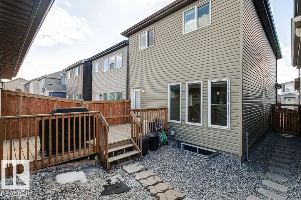 Rear exterior with light tan horizontal siding, featuring a multi-level wood deck with railings and a privacy fence - 17451 77 Street, Edmonton, AB - Outdoor With Deck Patio Veranda With Exterior