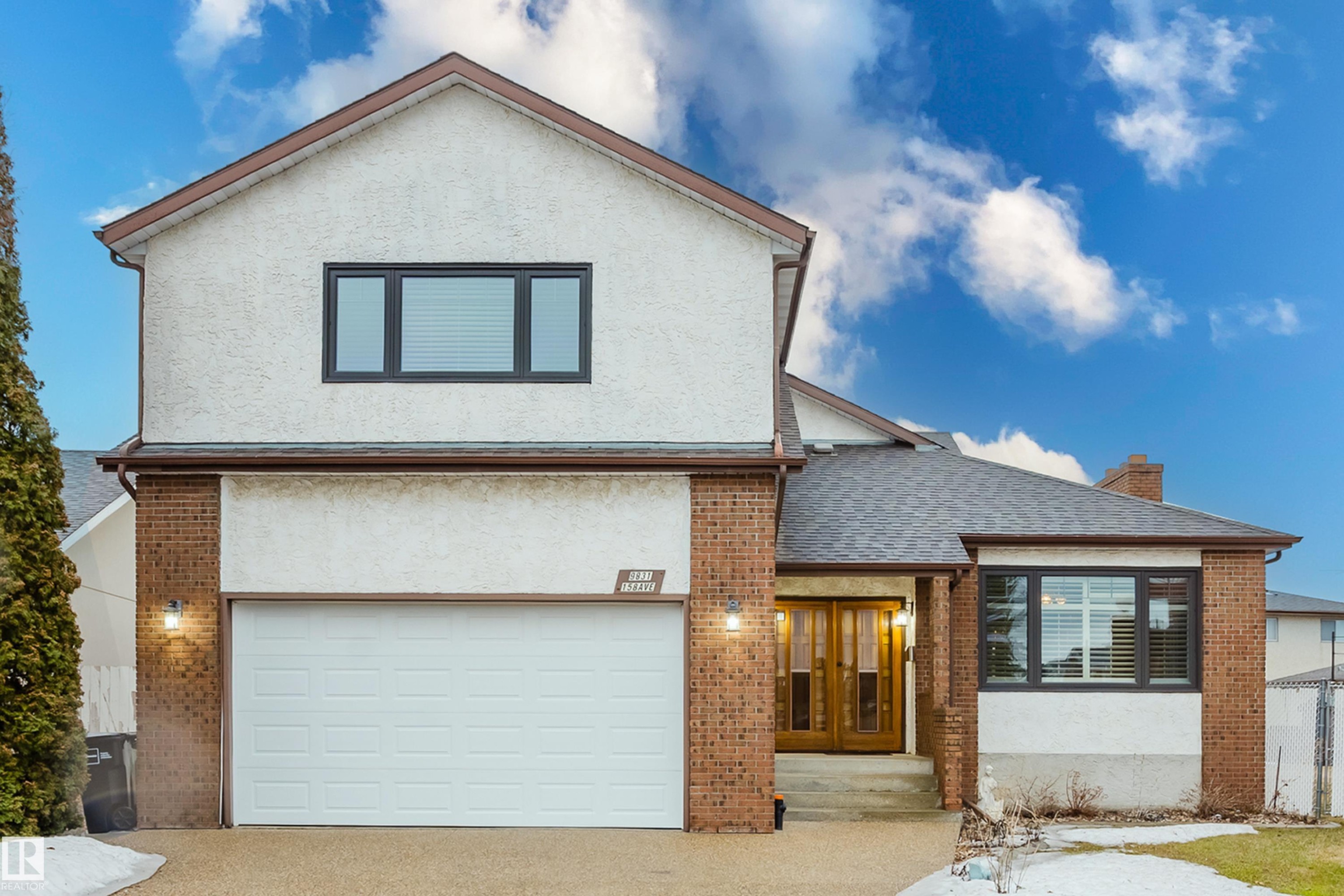 Two-story property featuring a white stucco and brick exterior, a two-car garage, and a peaked shingle roof - 9831 158 Avenue, Edmonton, AB - Outdoor
