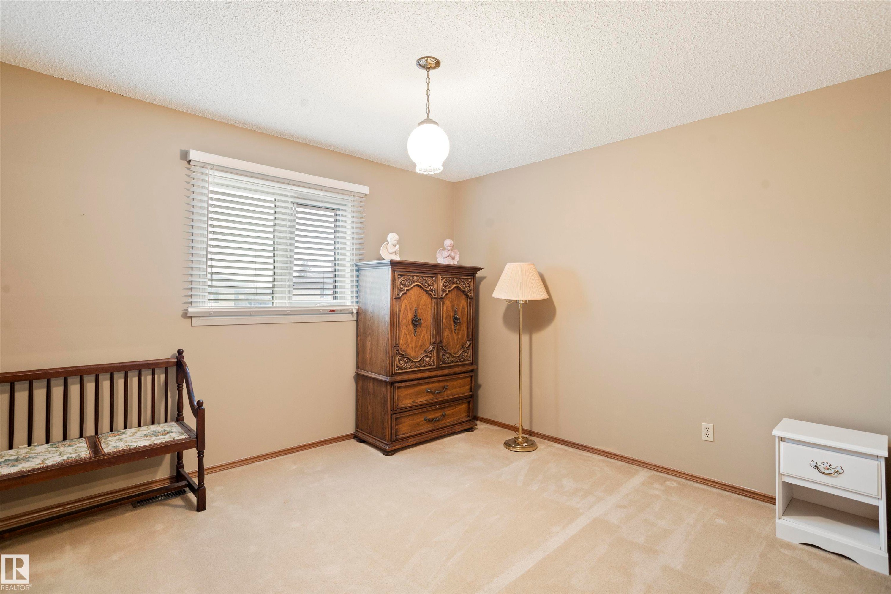 Carpeted room with neutral wall tones and a textured ceiling - 9831 158 Avenue, Edmonton, AB - Indoor