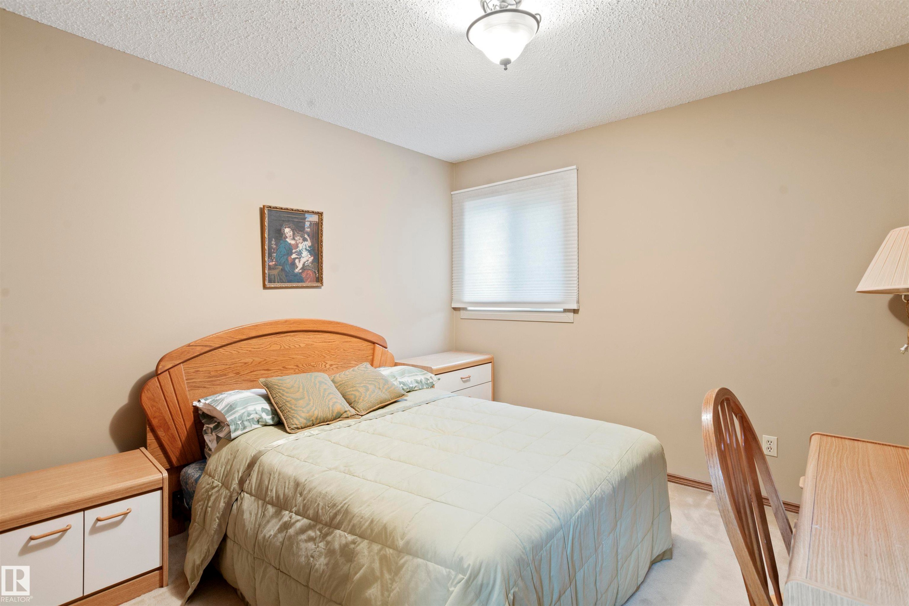 Bedroom featuring neutral wall paint, a window with horizontal blinds, and a ceiling-mounted light fixture - 9831 158 Avenue, Edmonton, AB - Indoor Photo Showing Bedroom
