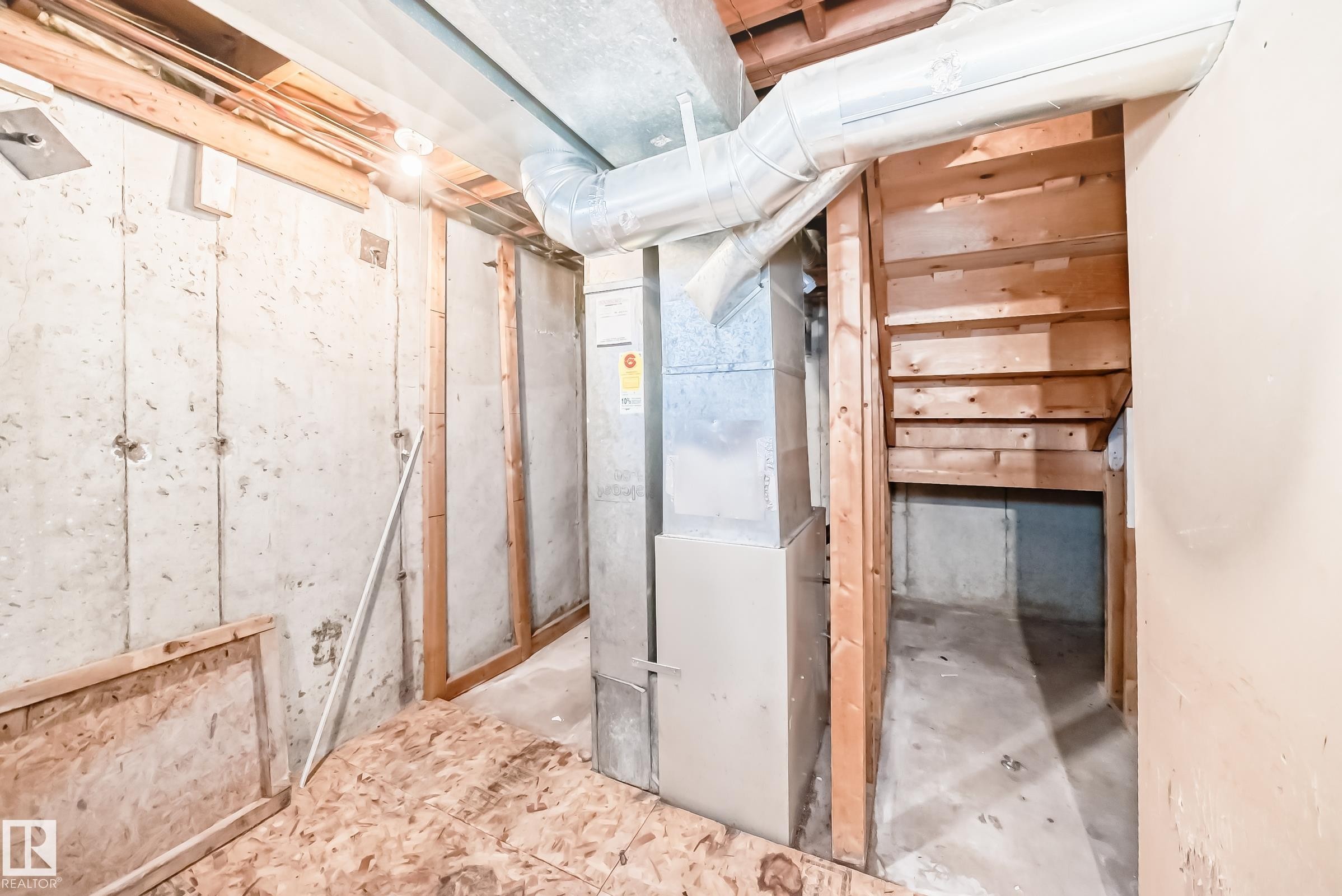 Unfinished basement space with exposed concrete walls, wooden framing, and visible ductwork - 8217 182 Street Nw, Edmonton, AB - Indoor Photo Showing Basement