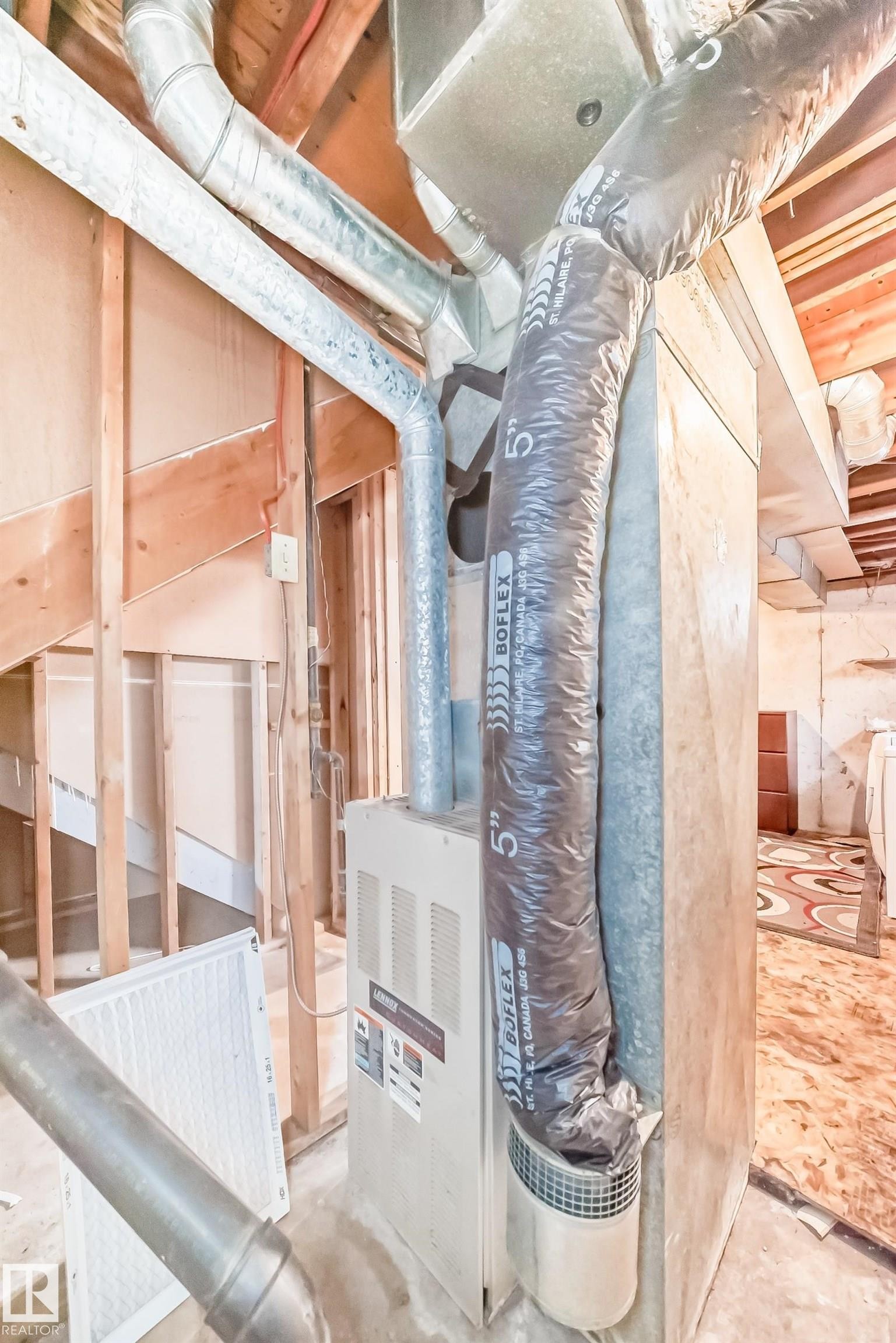 The property features a visible furnace unit, a range of ductwork, and exposed wooden framing - 8217 182 Street Nw, Edmonton, AB - Indoor Photo Showing Basement