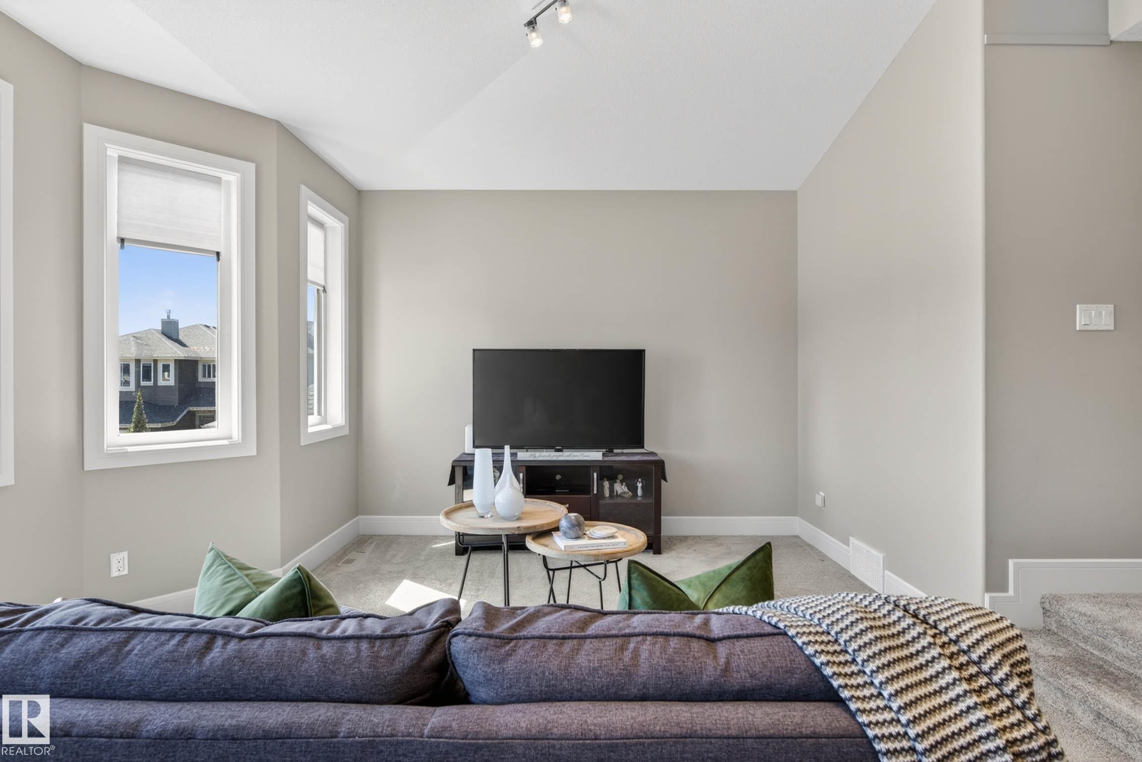 Bright living area featuring neutral wall tones, multiple windows, recessed lighting, and carpet flooring - 2086 Redtail Common, Edmonton, AB - Indoor Photo Showing Living Room