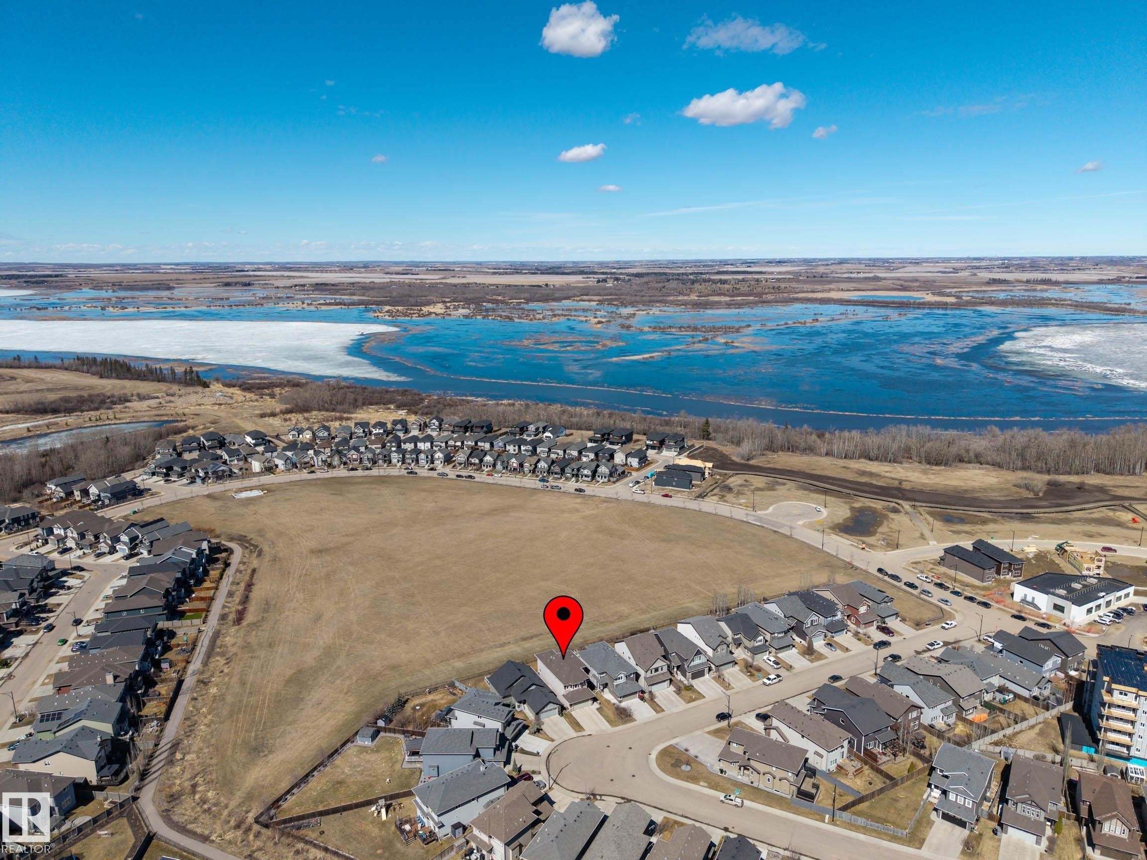 Aerial perspective showcasing a residential community positioned beside a large body of water, partially frozen - 2086 Redtail Common, Edmonton, AB - Outdoor With View