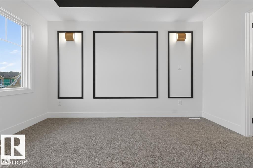 Spacious room featuring a large window, light gray carpeting, and a contrasting black tray ceiling - 55 Rosa Crescent, St. Albert, AB - Indoor Photo Showing Other Room